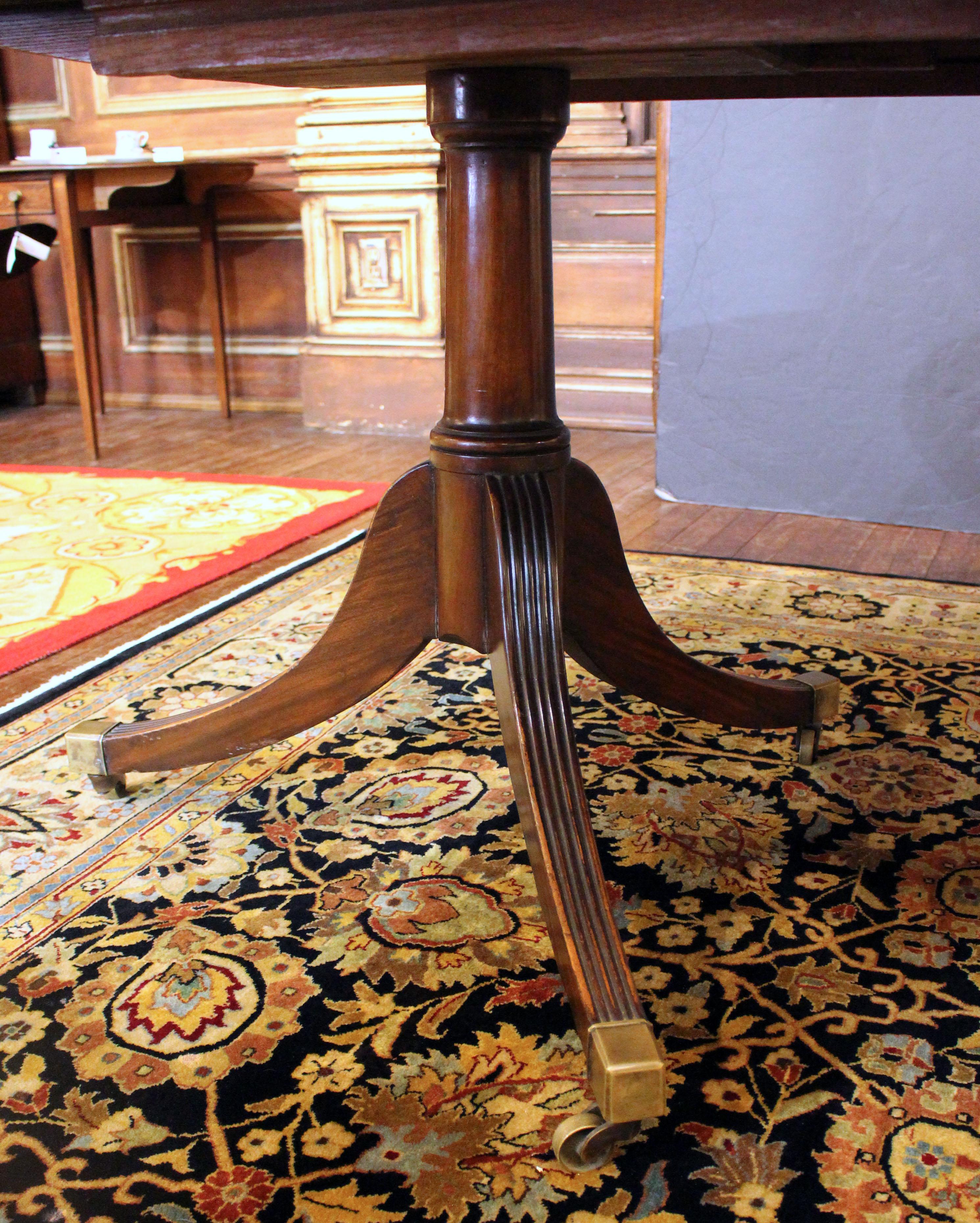Circa 1930 table de salle à manger à double piédestal avec feuille, anglais. Acajou massif. Style géorgien. Système d'extension intégré sous le plateau de la table pour soutenir le panneau, ce qui augmente la stabilité. L'ancien bris de jambe d'un