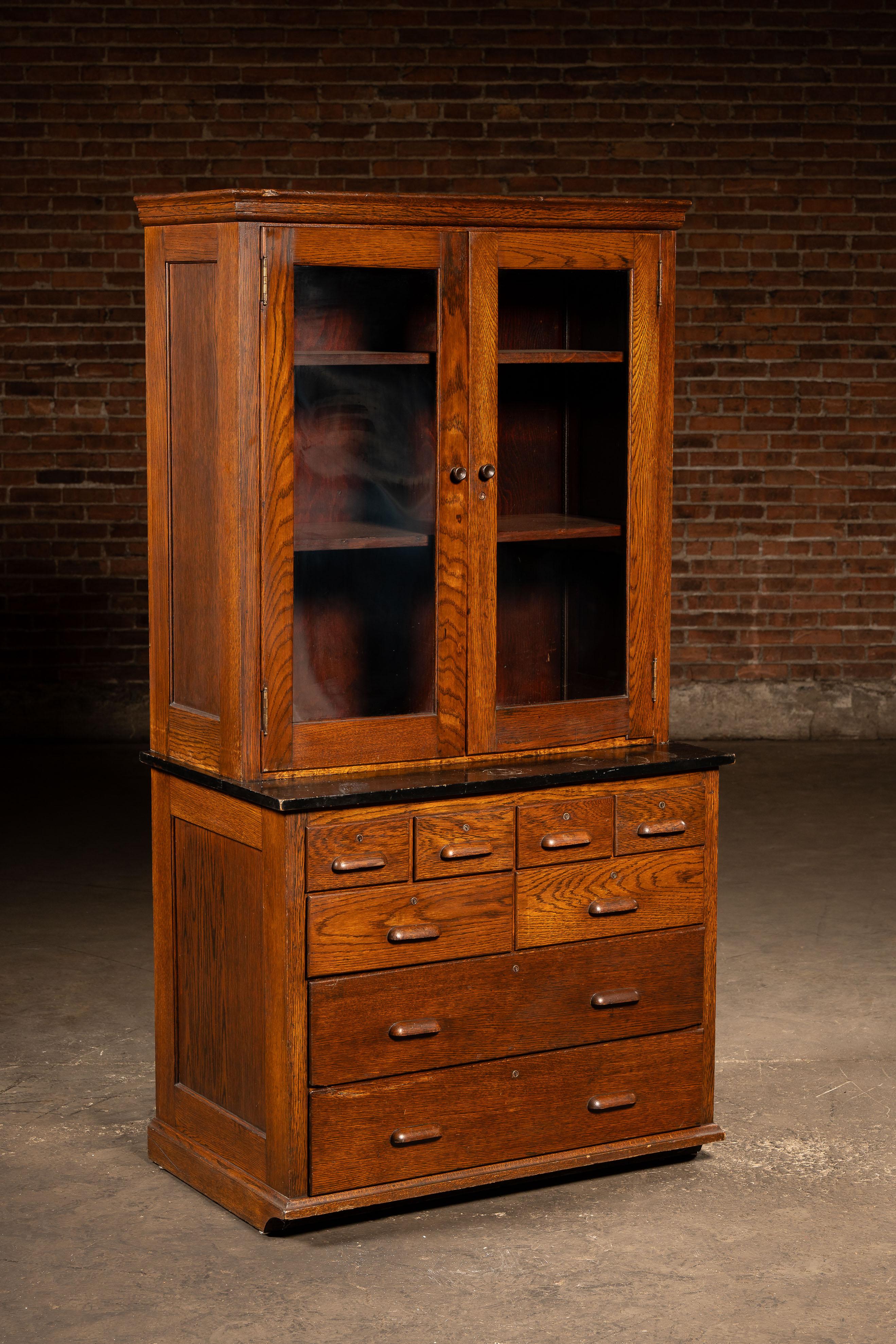 An early 20th century laboratory cabinet manufactured by Kewaunee Mfg. Co., who are still around today making cabinets all across the world. Featuring a sturdy set of eight drawers with rounded wooden handles.

This cabinet comes in two sections,