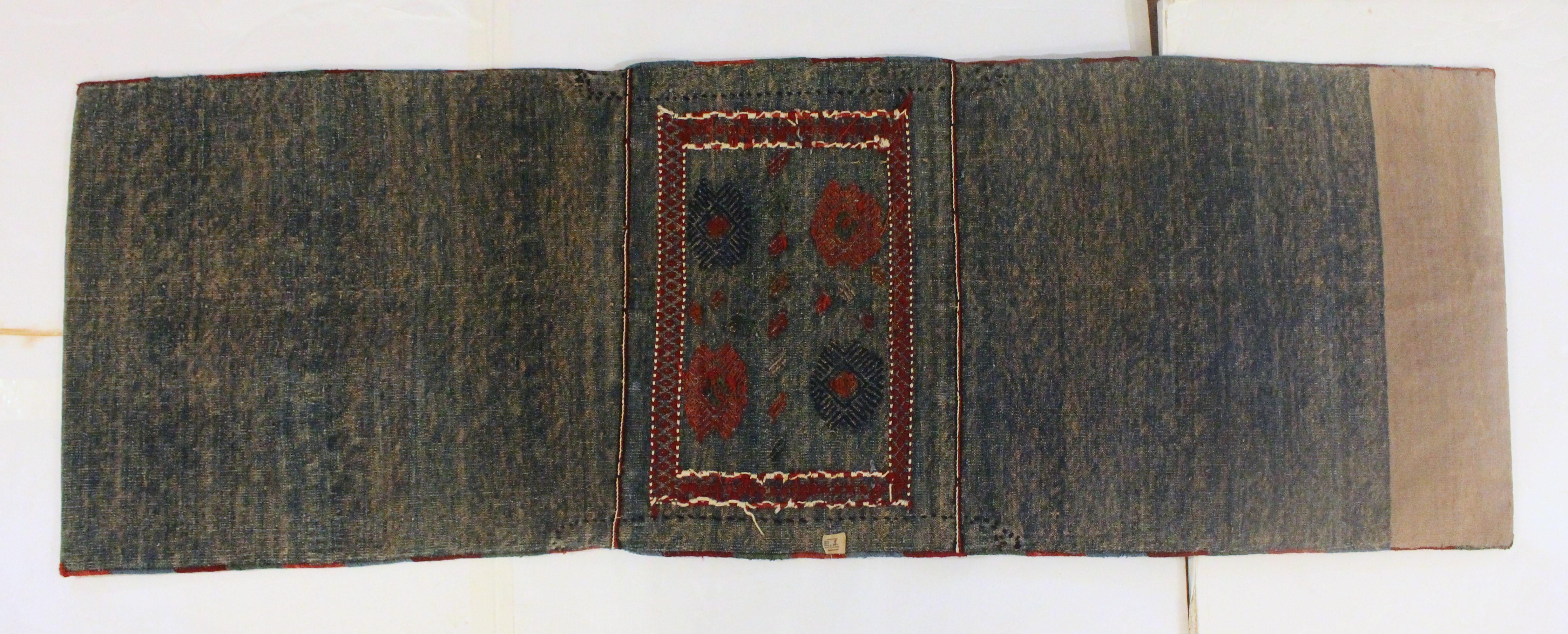 Alforjas de los años 30, Konya, en la región turca de Anatolia. El cuerpo de tejido plano azul y crema está bordado con coloridos diseños geométricos. Incluso se conservan los cordones, tal y como se atesoraba cuando se adquirió como regalo en los