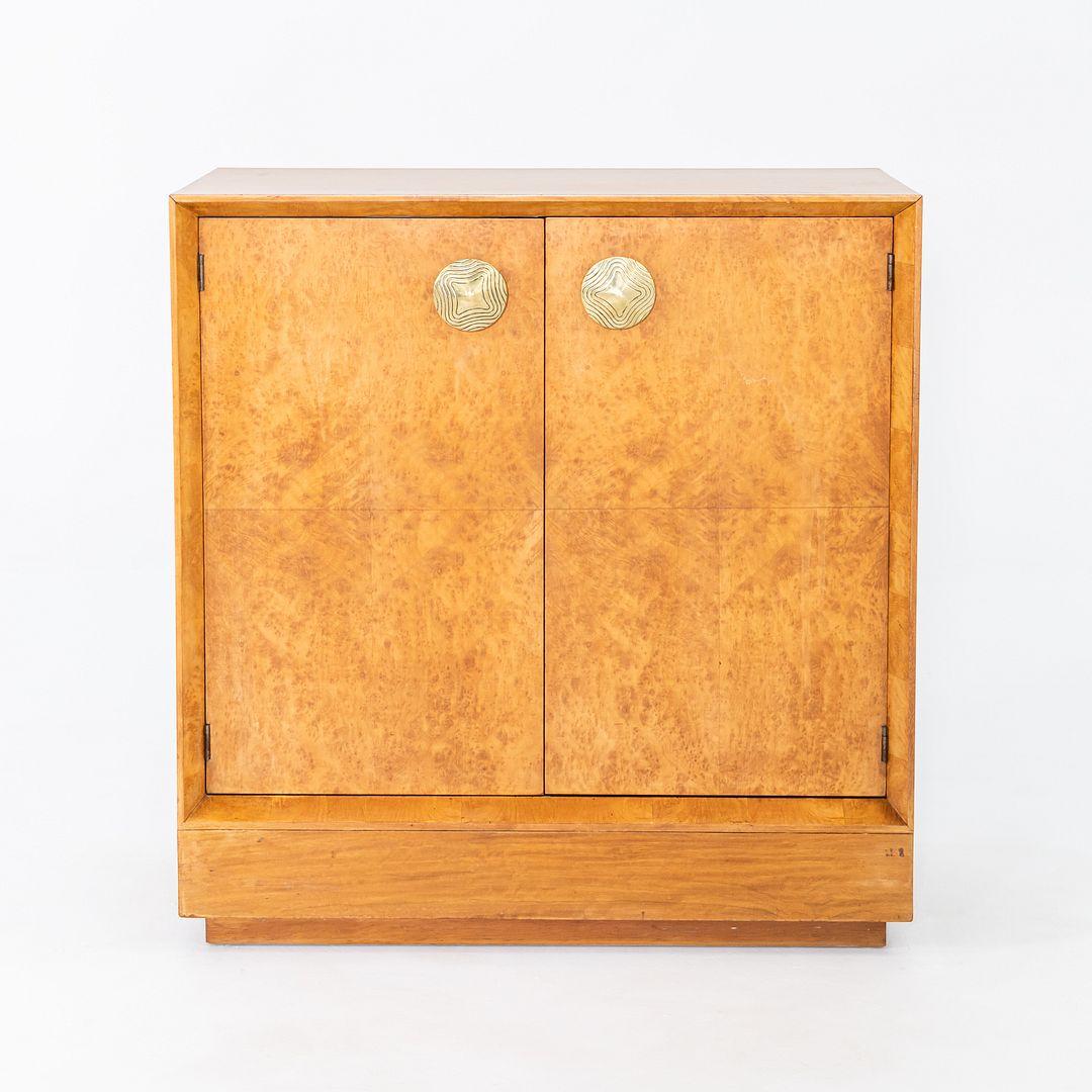 This is a Paldao Burled-Acacia Stereo Cabinet, Model 4103, designed by Gilbert Rohde for Herman Miller in 1941. This example dates to the same time. It was produced in the USA, and was featured in Herman Miller's first showroom design. Rohde was