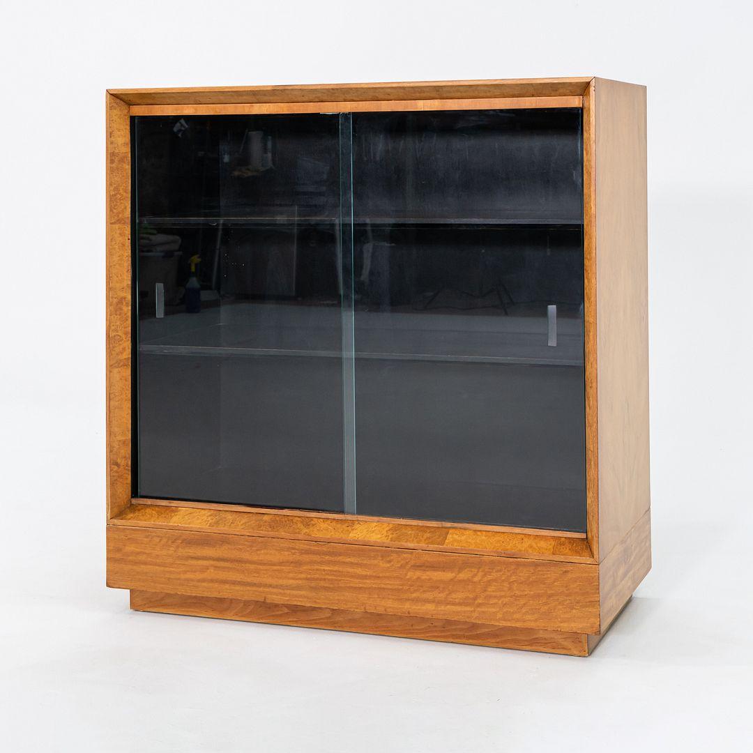 Il s'agit d'une armoire Paldao en acacia lustré et verre, conçue par Gilbert Rohde pour Herman Miller en 1940. Cet exemple date à peu près de la même époque. Il a été produit aux États-Unis et a figuré dans le premier design de salle d'exposition