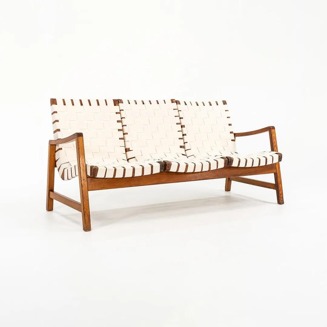 This is a three-seater settee, designed by Jens Risom for Knoll Associates in 1941. The piece has a frame constructed of pine (or possibly birch), and has newly re-done webbed straps. It is a true collector's piece and only very rarely seen. 
This