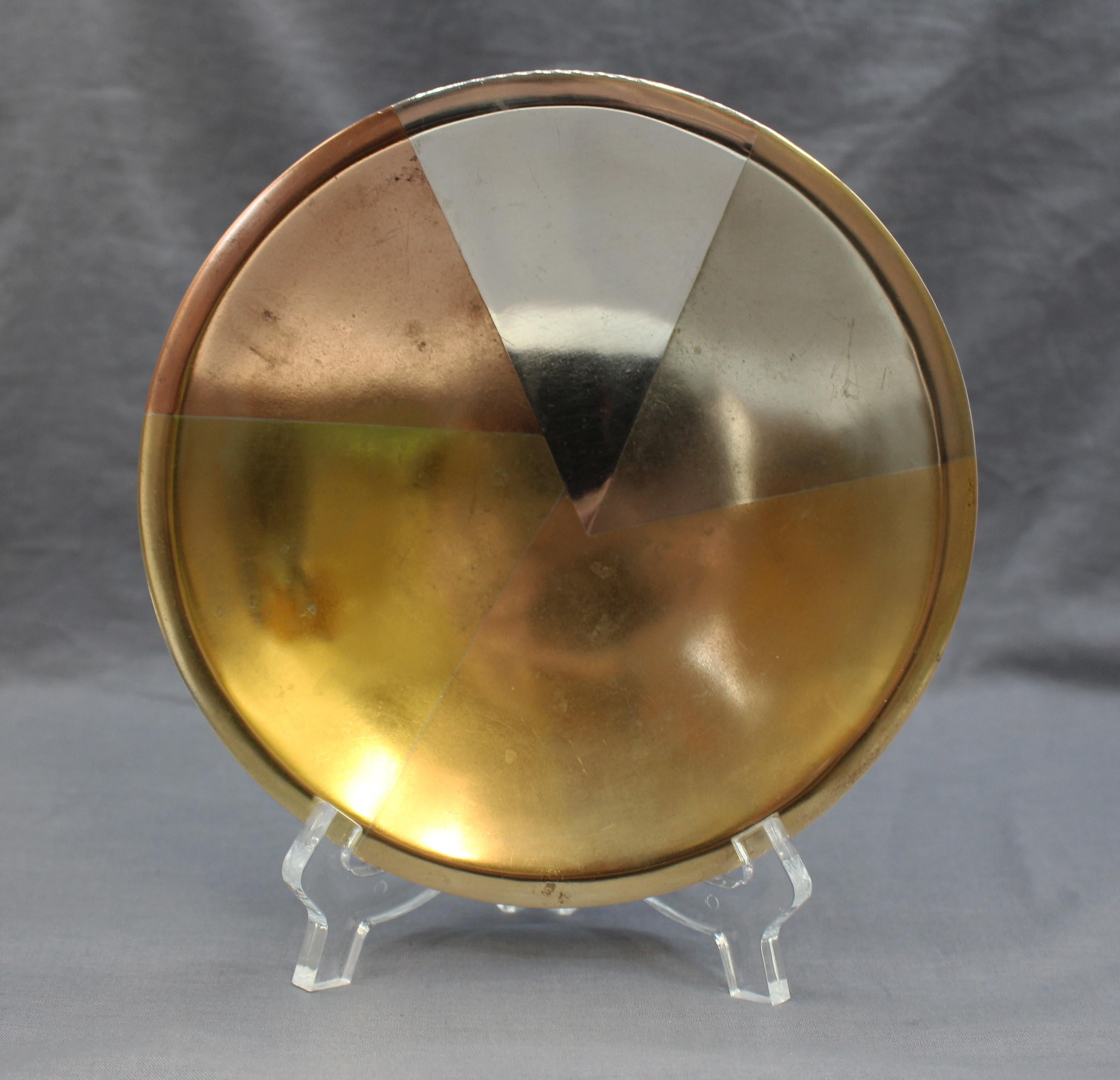 Los Castillo mixed metals card tray, Taxco, Mexico, circa 1950s. Hand wrought, raised on ring base. Copper, brass 
silver of various mixes for color. #95. Some surface scratches commensurate with age 
use.

6 5/8