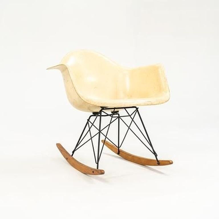 This is a ‚ÄòRAR‚Äô Rocking Chair, designed by Charles & Ray Eames in 1950. This particular chair dates to around 1956. The piece features a molded fiberglass-reinforced plastic shell seat in the coveted Parchment colorway. The base has black