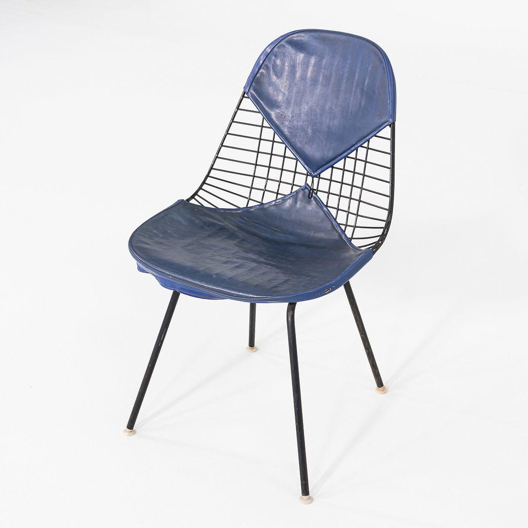 Il s'agit d'une chaise DKX-1 Wire Chair, conçue à l'origine par Charles et Ray Eames en 1951. Cet exemple a été produit par Herman Miller vers 1957. La chaise est dotée d'un cadre sculptural en fil d'acier noir associé à un pad bikini en deux