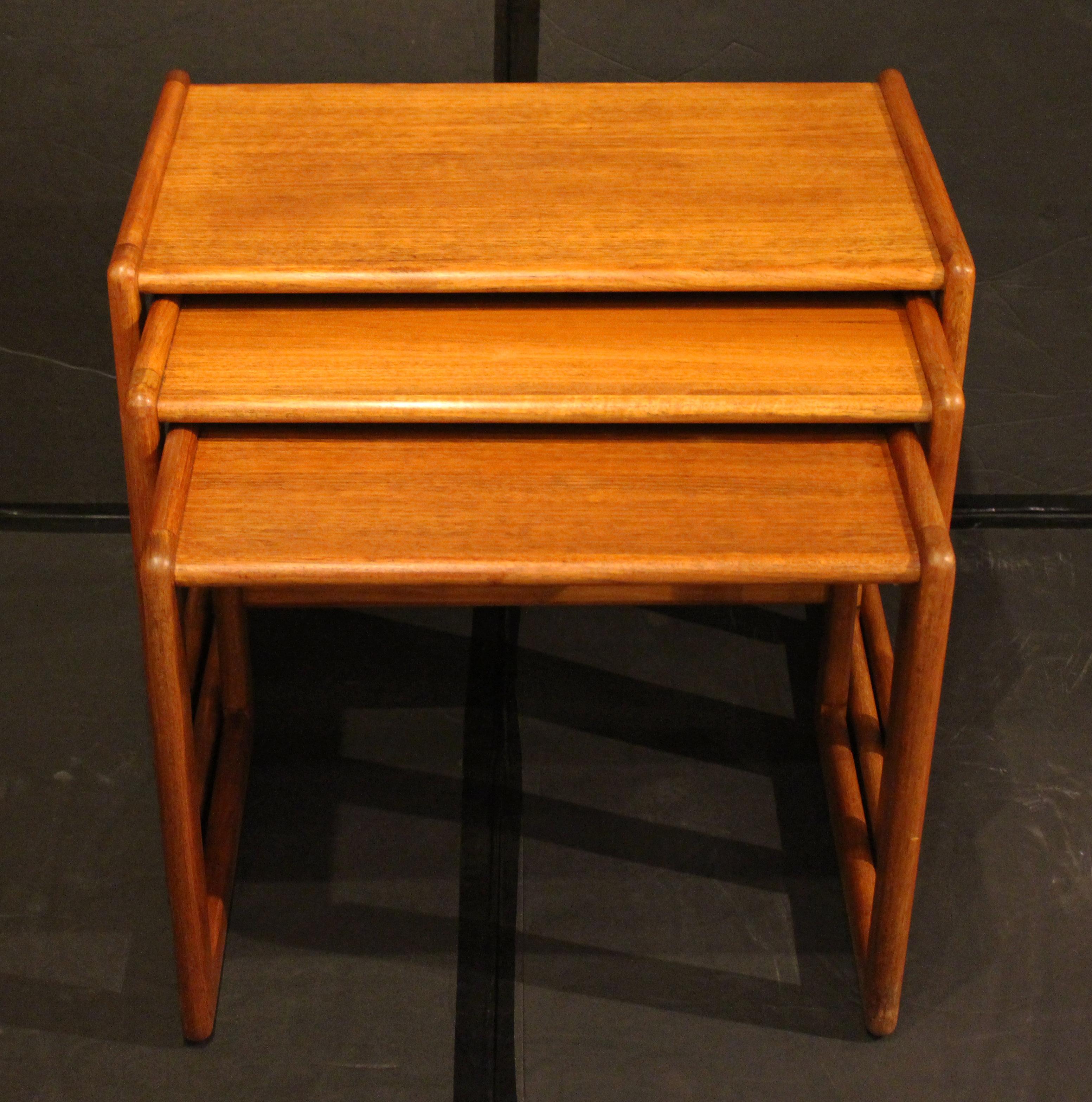 Circa 1960s set of 3 nesting tables, English. Mid Century Modern. Teak. Rounded edges. Square framed sides. Good use of contrast in the wood between the vertical & horizontal elements.
Largest: 23.5
