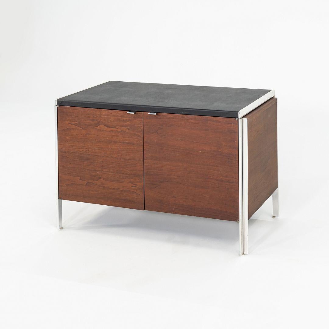 This is a Walnut Cabinet from the 'Electa Series', designed by Interior Designer Alexis Yermakov for Stow Davis in 1968. The series featured freestanding pieces with heavy chromed steel frames, which supported interchangeable panels of walnut,