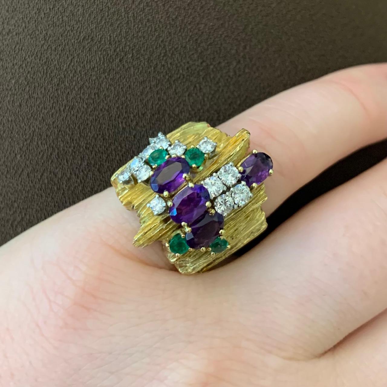 An amethyst, diamond, emerald and 18 karat textured gold ring, by Henry Dunay, c. 1970, United States. This ring is signed Dunay 18k. Size 5.  

This is an earlier ring by Dunay, luscious and sparkling. 

Henry Dunay won a Diamonds International