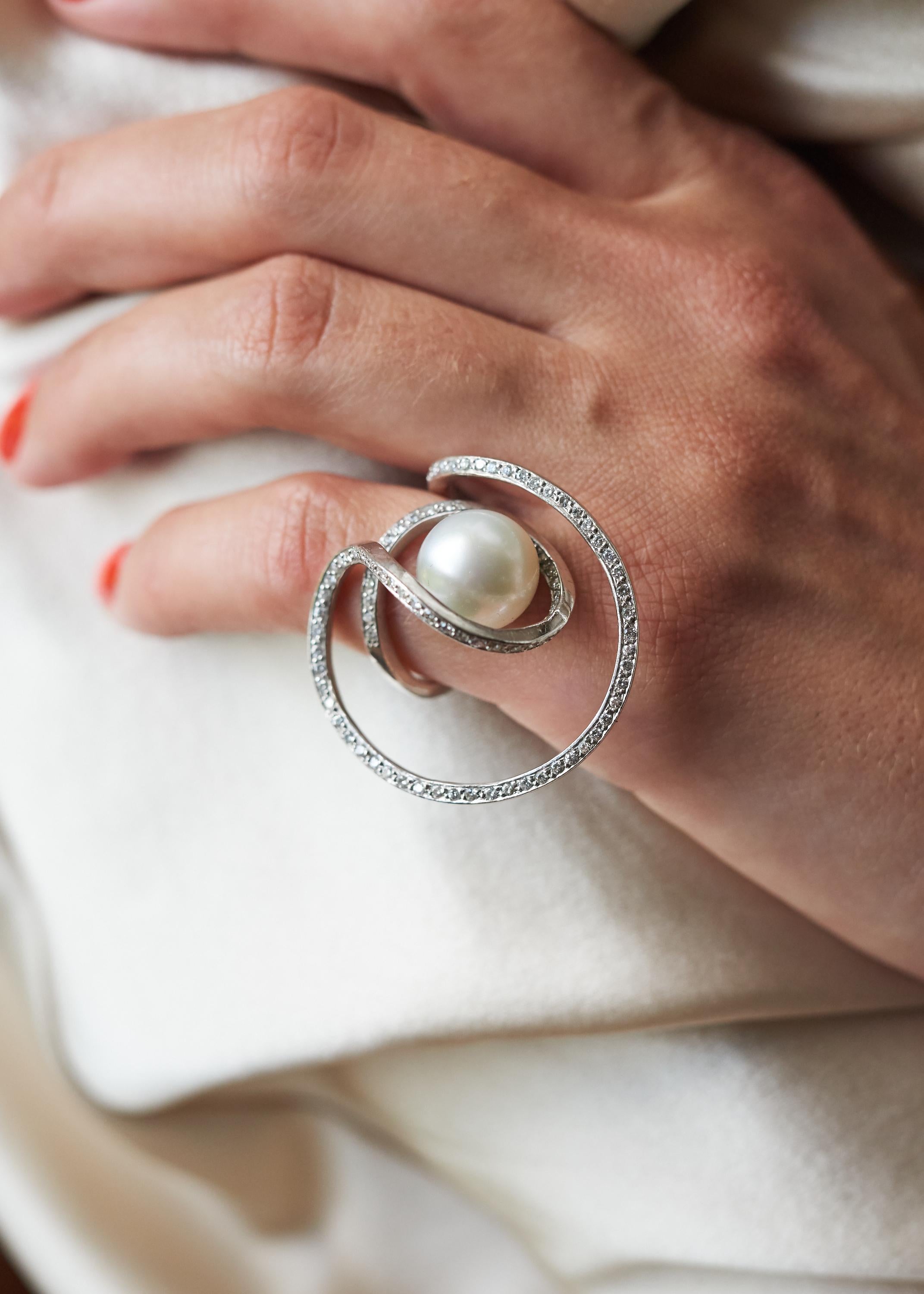A diamond, cultured pearl and 18 karat white gold ring, by Jean Vendome, c. 1970. Stamped with maker's mark and French assay. Set with approximately 1.15 carats of round brilliant cut diamonds, ring size 4.

An elegant and inspiring jewel by Jean