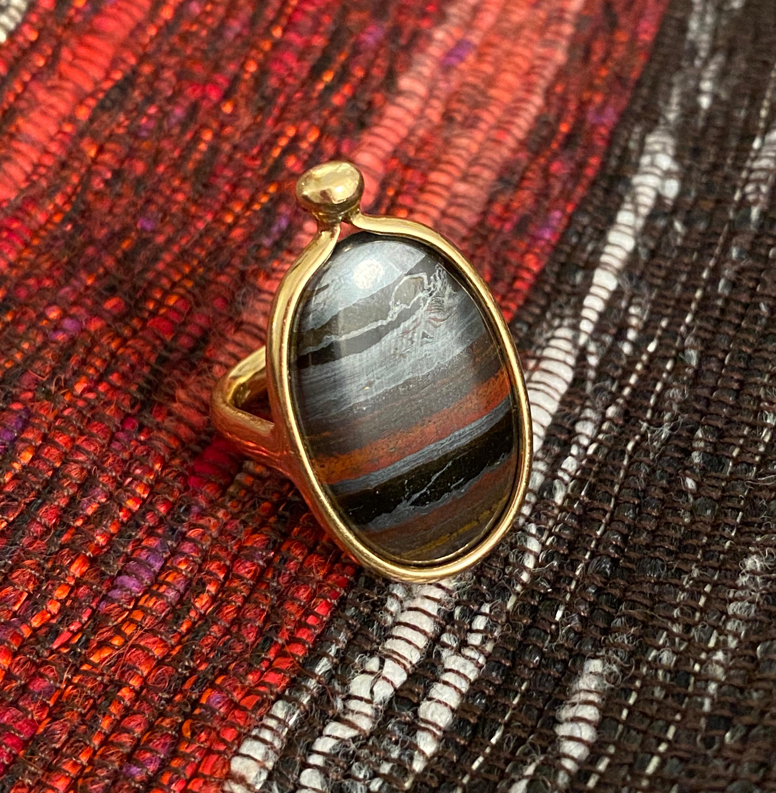 Ein Ring aus Eisenstein und 18-karätigem Gold, hergestellt von Vivianna Torun für Georg Jensen, Dänemark.  Signiert Torun, 1424 Georg Jensen 750. 
Der Ring hat die Größe 6,50. Aufgrund der Platzierung der Punzierungen ist dieser Ring nicht groß.
