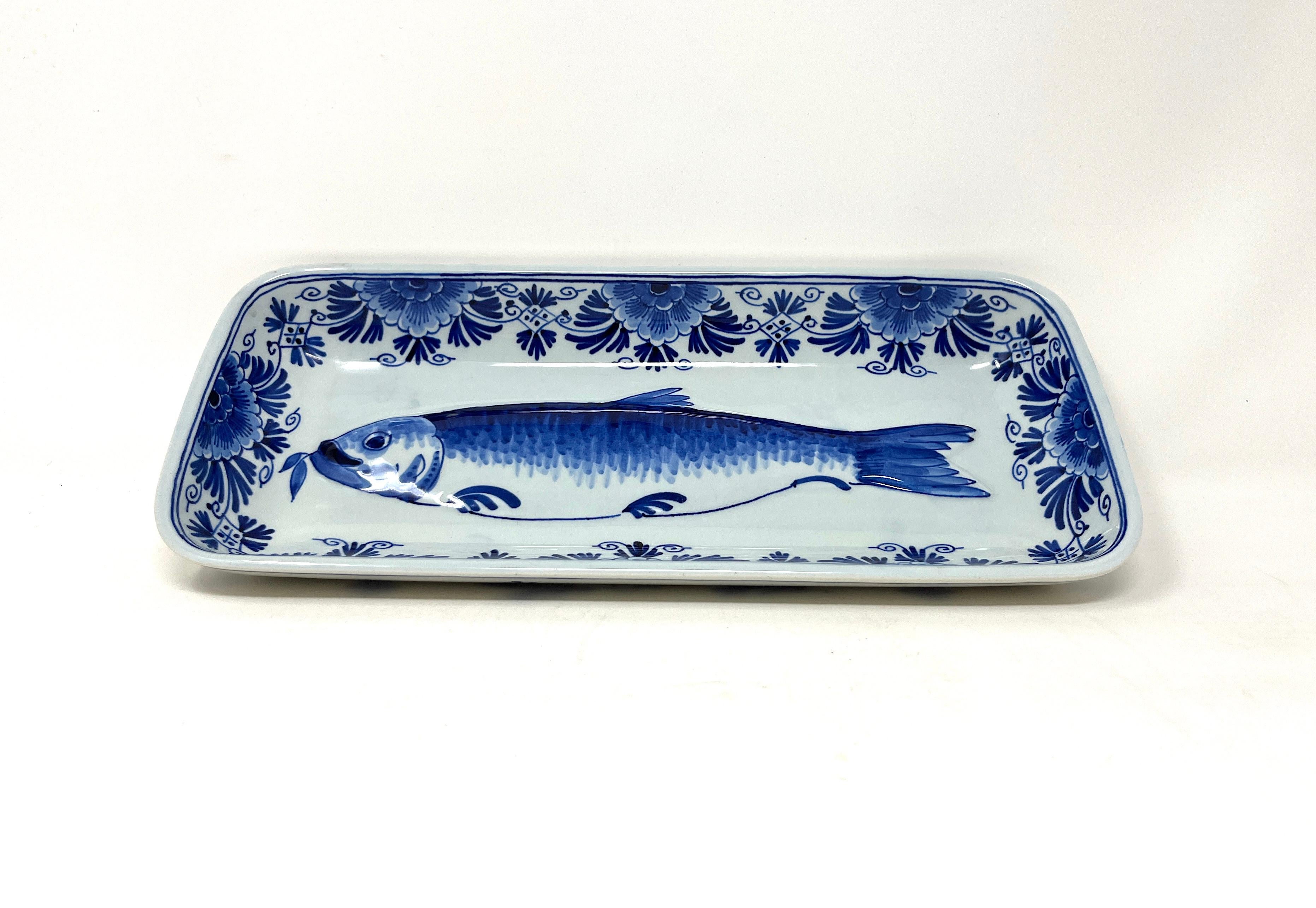 Esta porcelana vintage pintada a mano de Royal Delft, fabricada en Holanda, es una fuente o plato de servir de arenque. 

Desde 1879, cada artículo pintado a mano producido por De Koninklijke Porceleyne Fles lleva una marca como ésta, consistente en