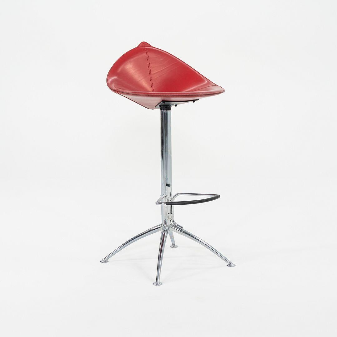 This is a set of three Fiorile Bar Stools, designed and produced by Fasem in Italy. These particular examples are from the 1980s. The stool's design is comprised of a steel frame and has a seat that is upholstered in red leather. 
 
 Each stool