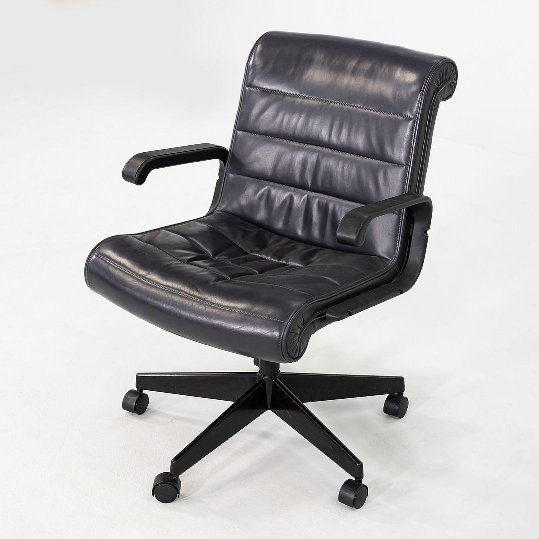 This is a Management Desk Chair designed by Richard Sapper, originally introduced for Knoll in 1979. This particular example dates to around 2001. It features grey leather upholstery with a polished aluminum five-star base and integrated tilt