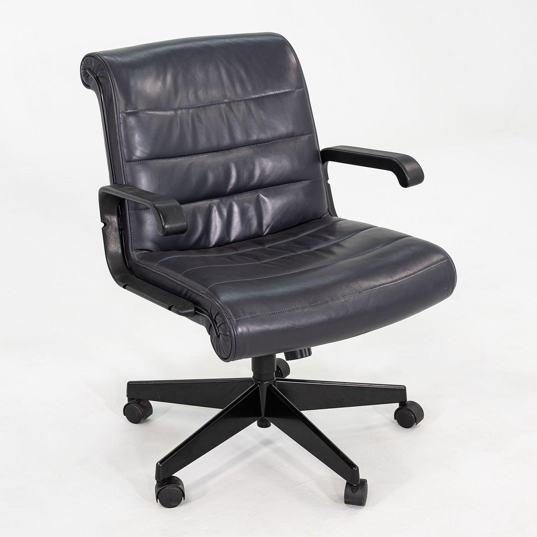 This is a Management Desk Chair designed by Richard Sapper, originally introduced for Knoll in 1979. This particular example dates to around 2001. It features grey leather upholstery with a polished aluminum five-star base and integrated tilt