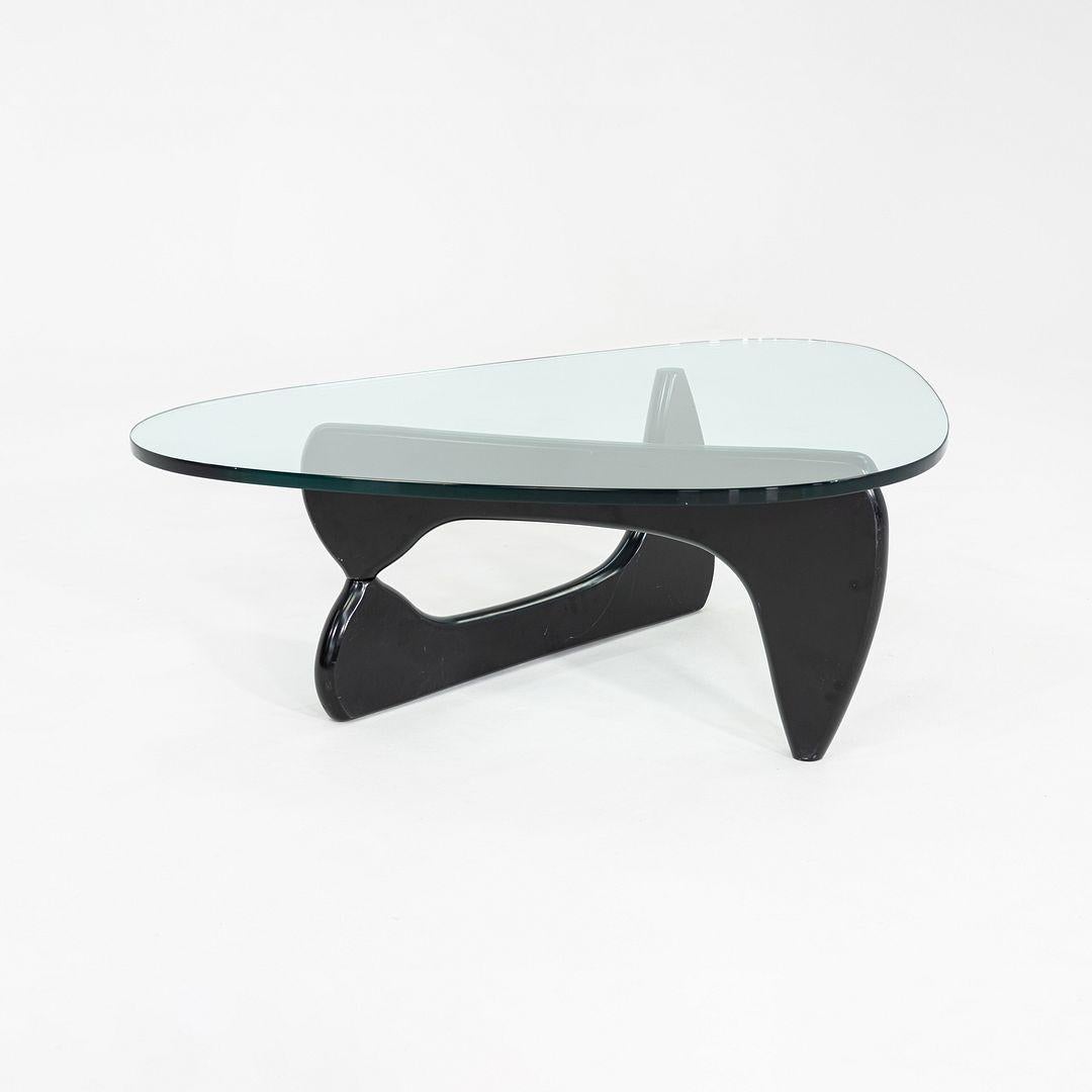 This is a Noguchi Coffee Table, originally designed by Isamu Noguchi for Herman Miller in 1947. This particular example was produced in the United States circa 2007. The table features a black-lacquered solid wood base supporting a freeform,