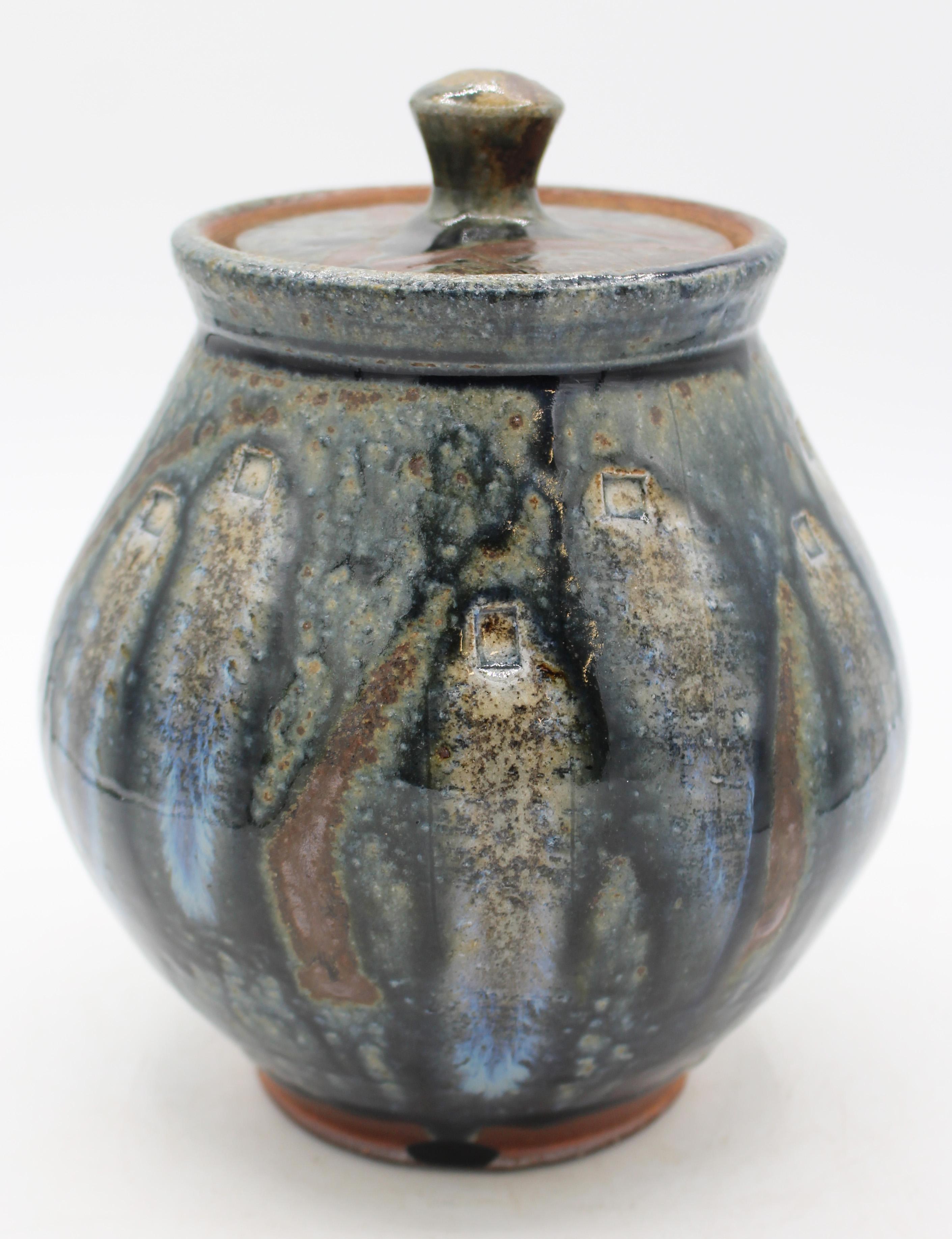 Colorful covered jar, Mark Hewitt Pottery by apprentice Seth Guzovsky, 2010-12. Mark Hewitt's distinctive rectangular impressions and glass runs are taken to a dramatic level in this piece. 7.5
