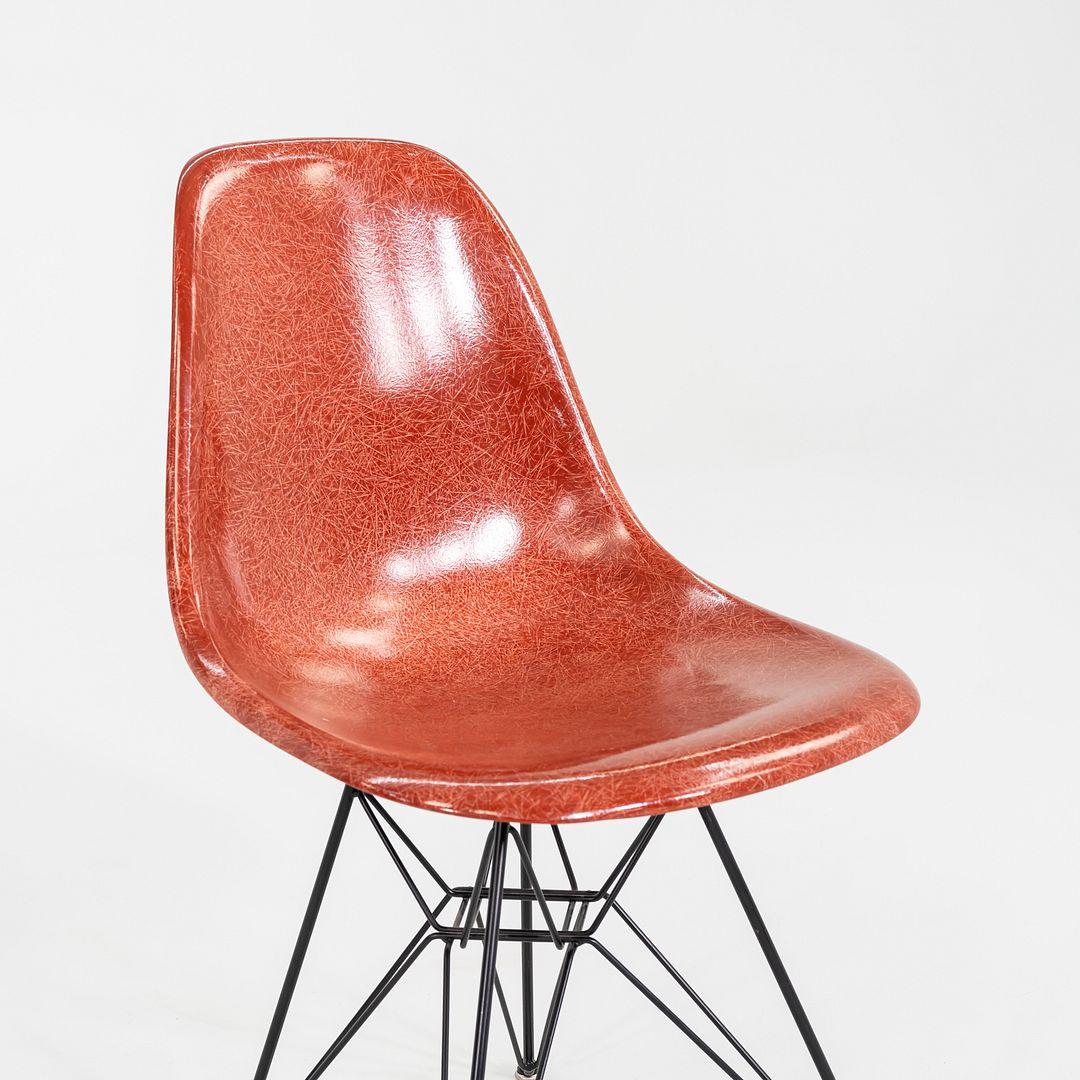 This is an Eames DSR chair, originally designed by Ray and Charles Eames in the 1950s. This particular example was produced by Modernica in the USA C. 2018. The chair features a fiberglass shell in red, and has an Eiffel base made of steel. DSR is