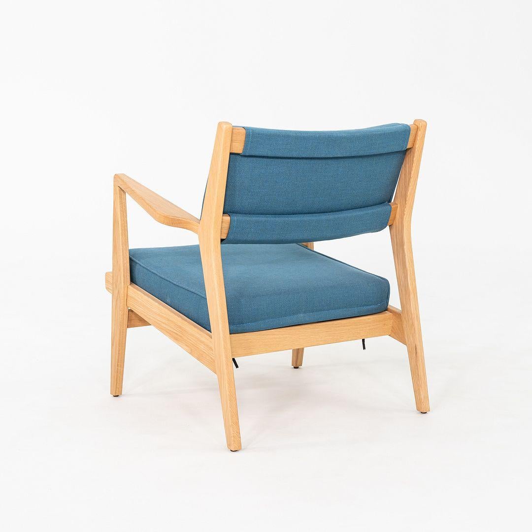 This is a pair of U-430 Lounge Chairs with arms, originally designed by Jens Risom in 1955. These particular examples were produced by Design Within Reach in the year 2020. Their design is comprised of an oak frame with a seat upholstered in blue
