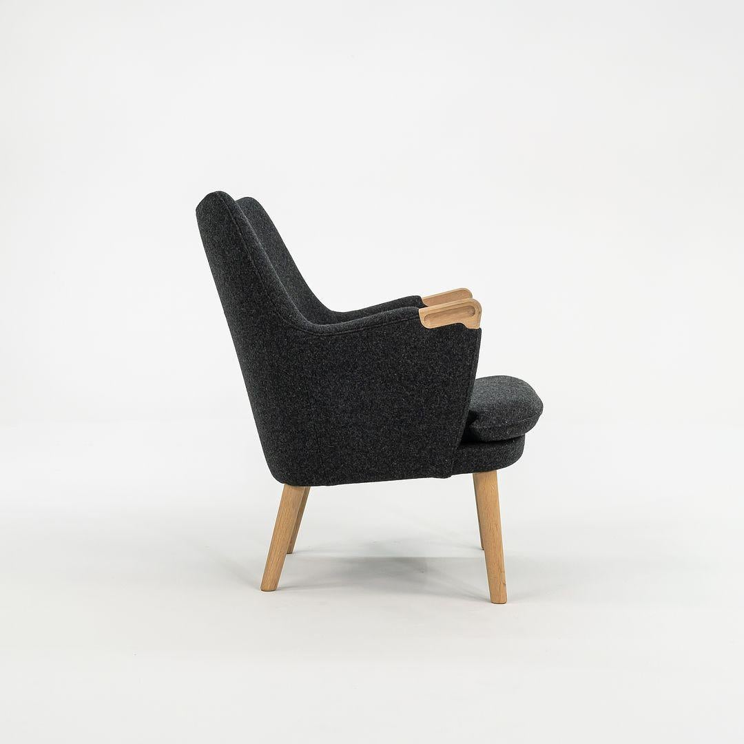 Der CH71 Lounge Chair besteht aus einem massiven Eichenholzrahmen und ist mit grauem Wollfilz bezogen. Der Stuhl wurde von Hans Wegner entworfen und von Carl Hansen & Son in Dänemark hergestellt. Er datiert ca. 2021 und ist garantiert echt. Es ist