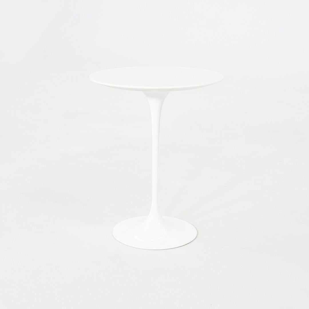 This is a Tulip Pedestal Side Table, initially designed in 1956 by Eero Saarinen for Knoll. This particular piece was produced in 2022. The base is formed of molded cast-aluminum which is powder-coated in a white satin finish. Its top is made of