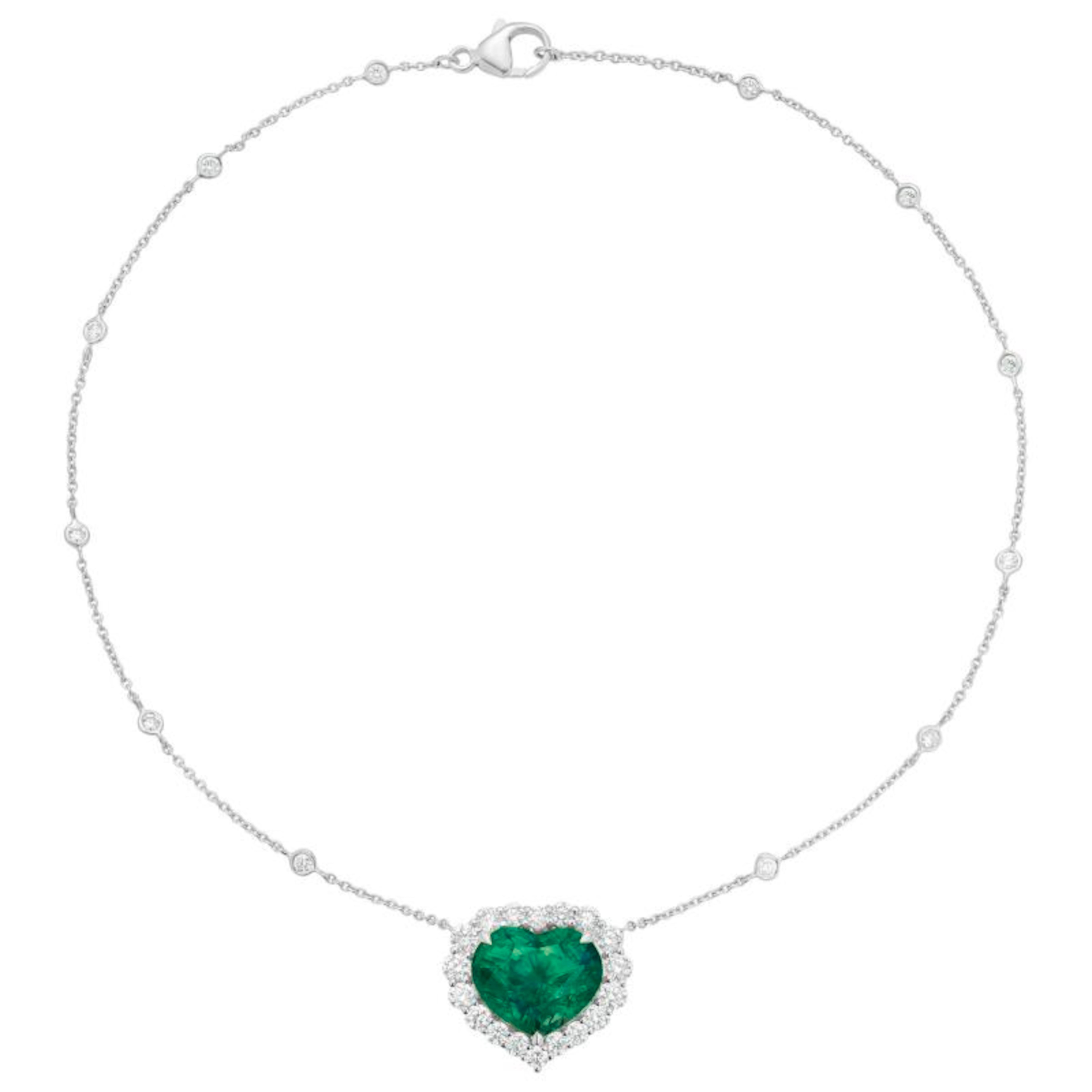 An exquisite 13 carat heart shape emerald certified by C.Dunaigre as minor oil set in a bezel necklace with a halo of round brilliant cut diamonds.