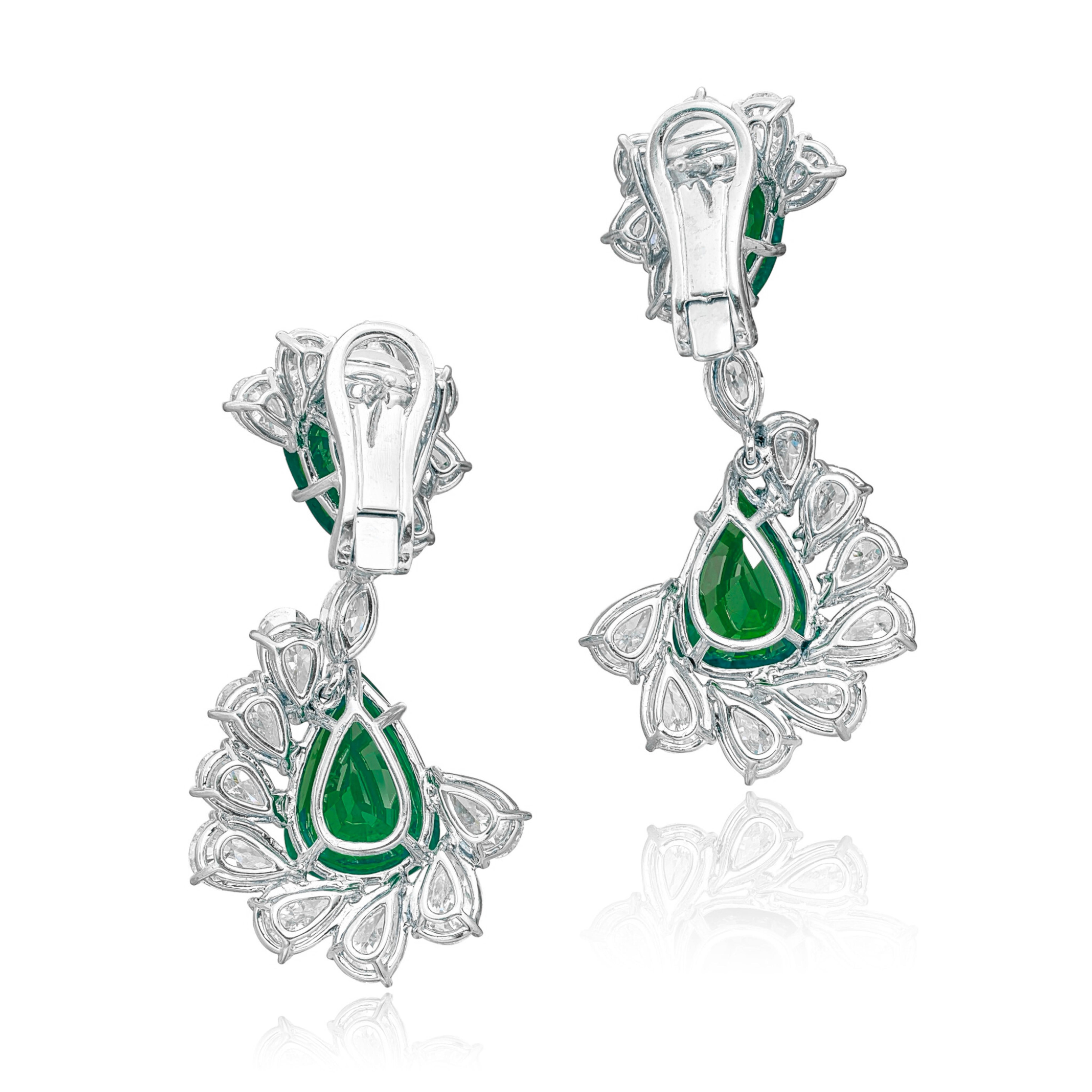 These exquisite earrings feature stunning pear-shaped emeralds weighing 3.15 and 2.86 carats, elegantly suspended to enhance your look. Each emerald is beautifully complemented by an ornate arrangement of pear- and marquise-shaped diamonds, adding a