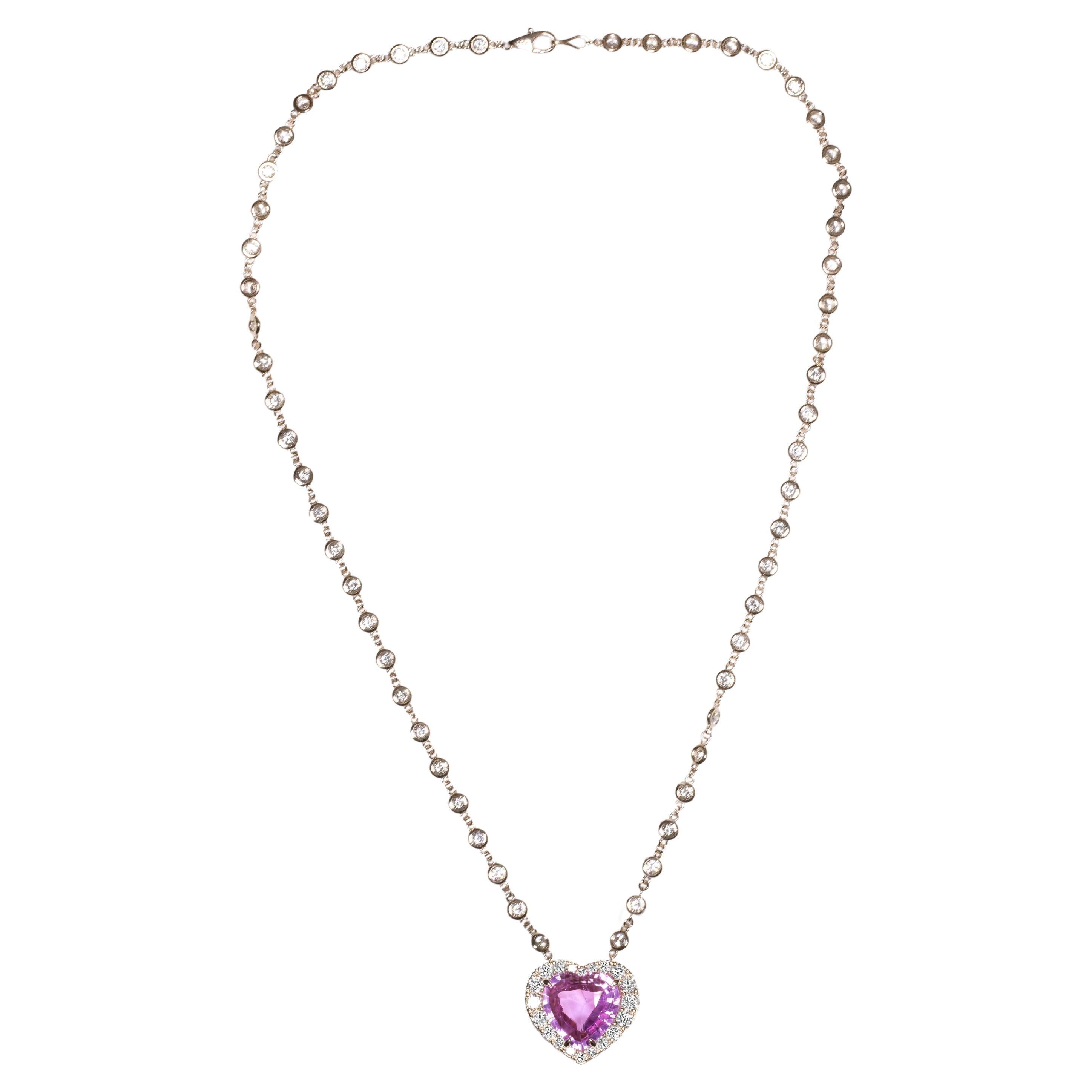 Un exquisito zafiro rosa de Ceilán Sri-Lanka de 10,11 quilates  engastado en oro rosa de 18 quilates

el colgante tiene un halo de diamantes redondos talla brillante F de color y claridad VS

el peso en quilates de los diamantes laterales es de