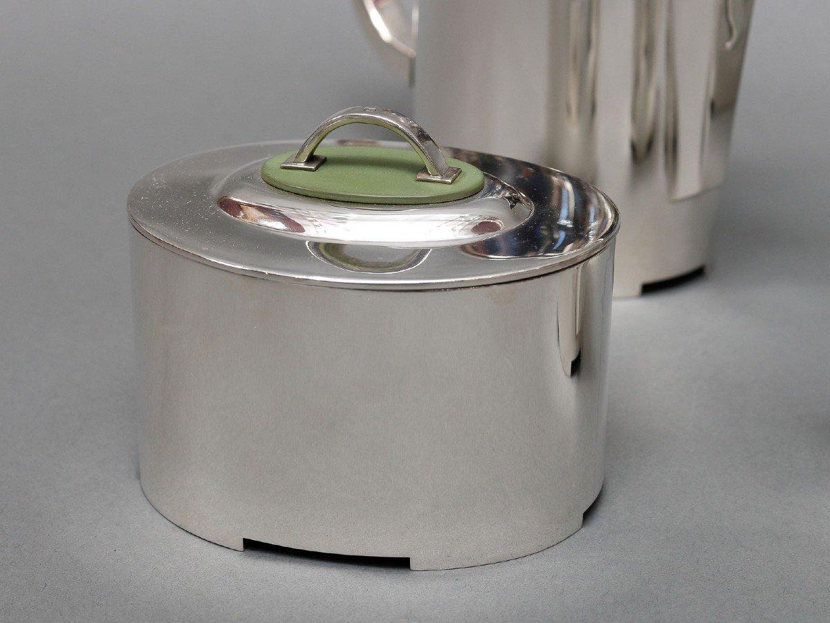 Modernist solid silver tea/coffee service in an oval shape consisting of a teapot, a coffee maker, a milk jug and a sugar bowl. Each piece has a lid whose grip is fixed on an oval resin plate.
Dimensions / teapot: 21 cm x 9 cm height 12 cm - Coffee