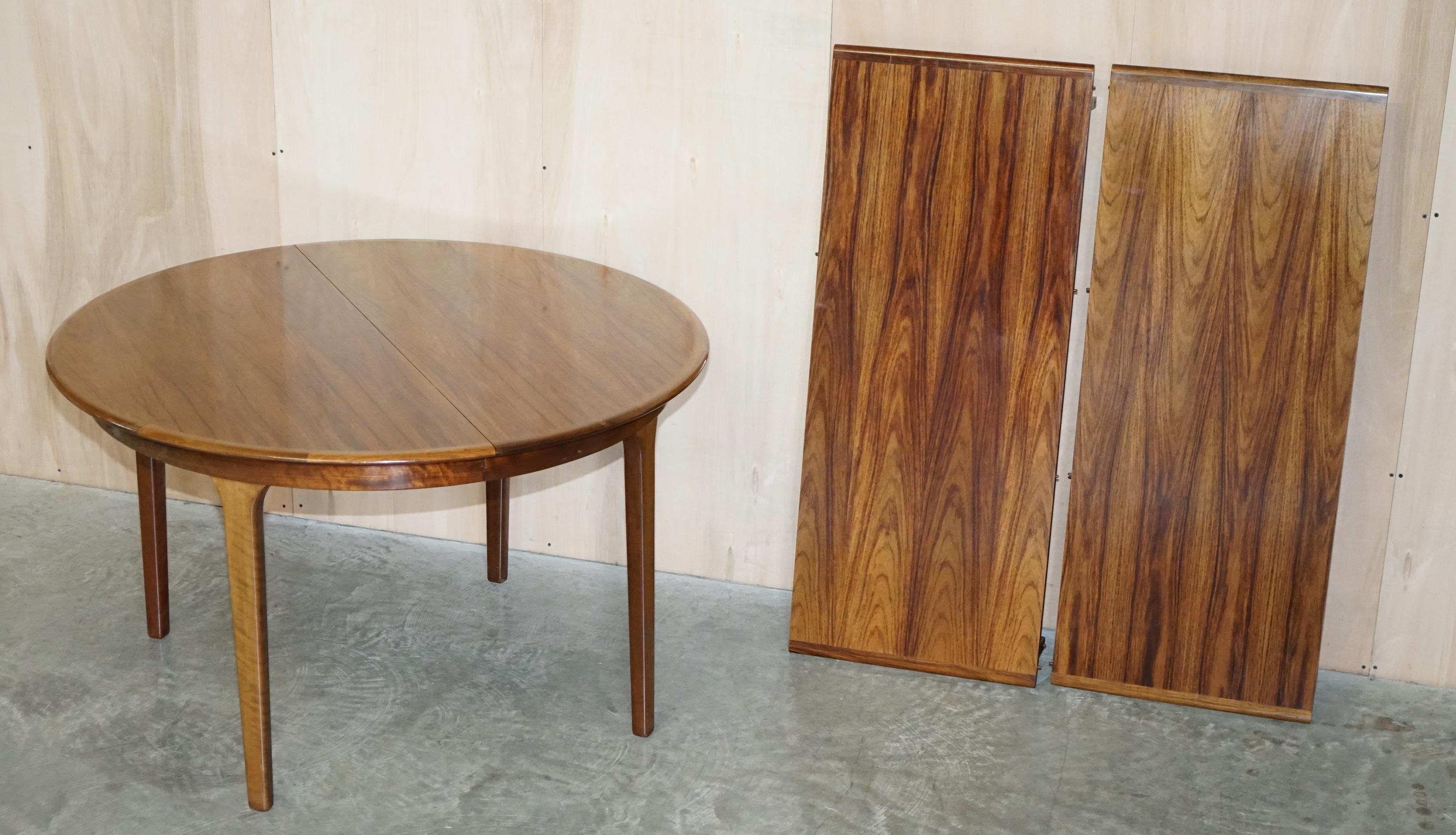 Nous sommes ravis de proposer à la vente cette superbe table de salle à manger en bois de rose danois, moderne du milieu du siècle, de marque C.J Rosengaard, qui peut accueillir jusqu'à huit personnes lorsqu'elle est entièrement déployée.

Très
