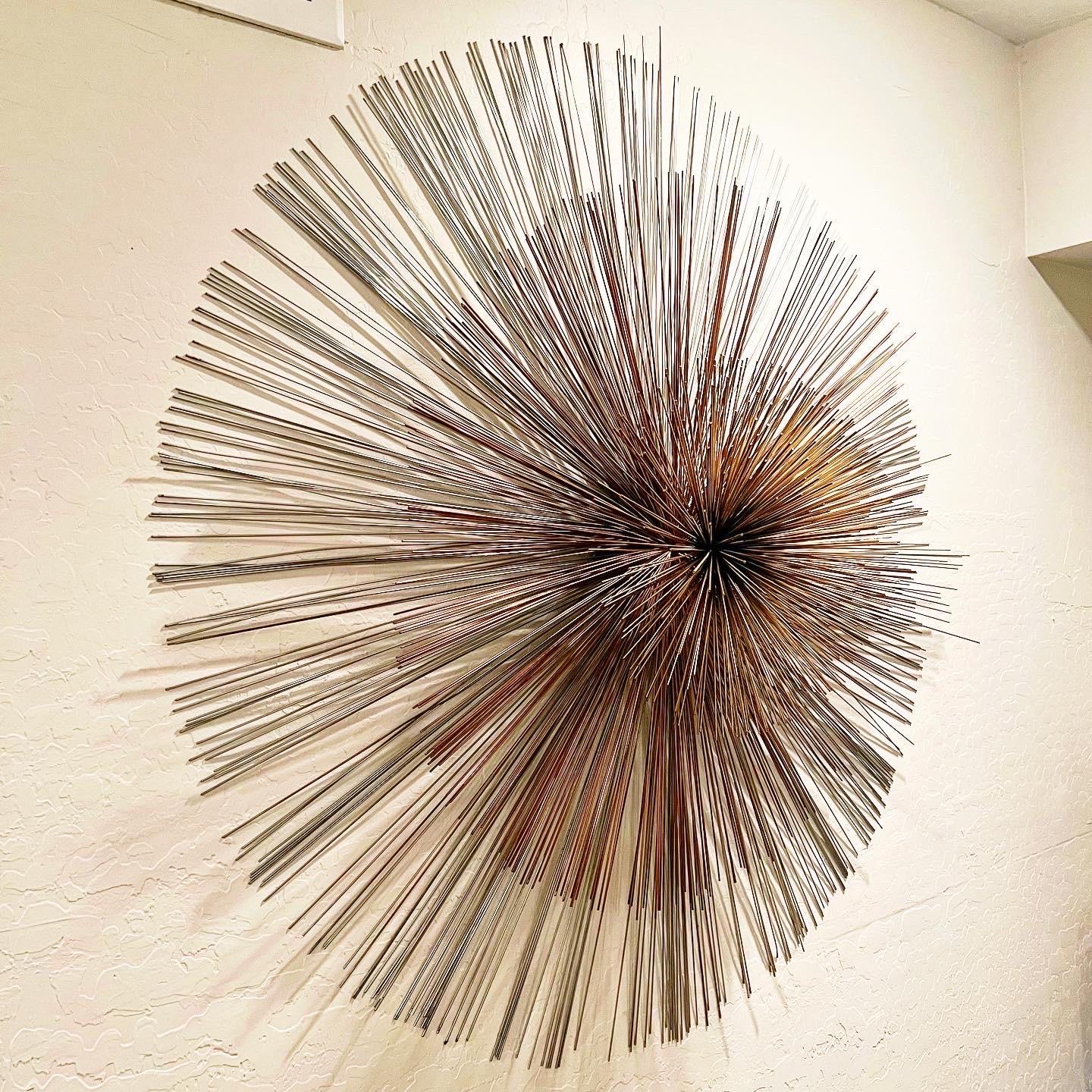 C. Jeré 1987 urchin or pom pom brass wall art, extra large round version about 41” wide and 11” deep. Made of three layers with different metallic colors: chrome/silver, copper and brass. Signed on the back and in great condition. 