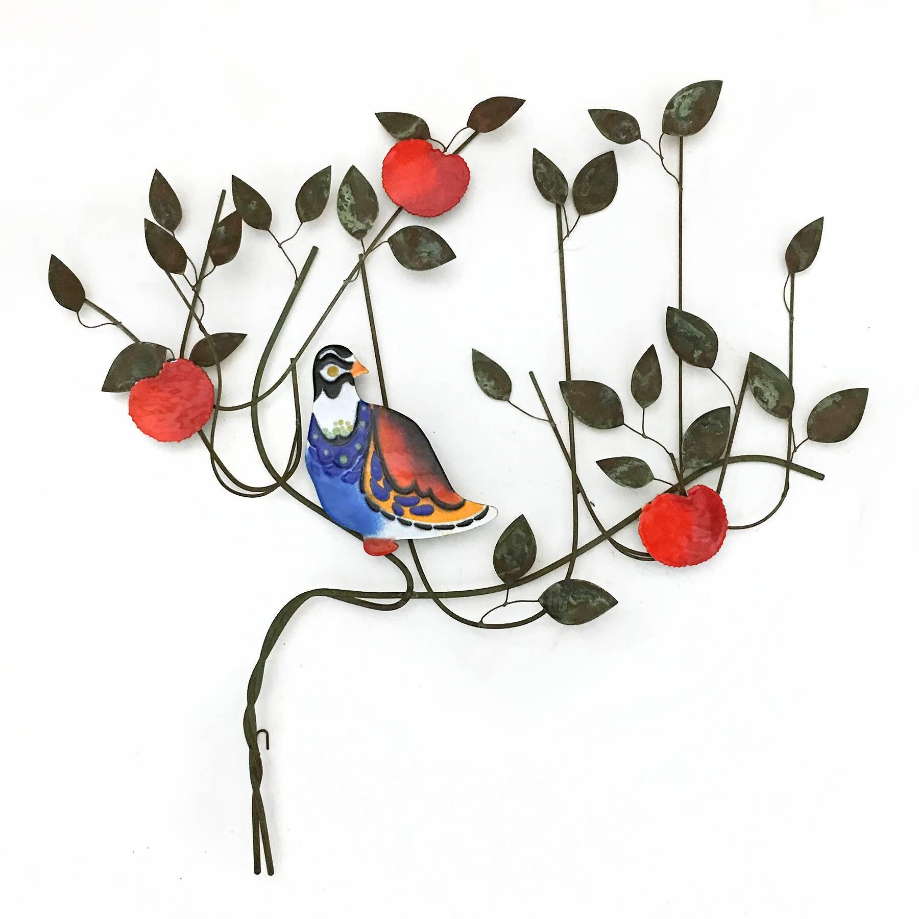 This uncommon Jeré wall sculpture from 1970 features a vividly colored bird resting in a fruit tree. It combines a wire composition of lyrical lines with patinated leaves and enameled elements.