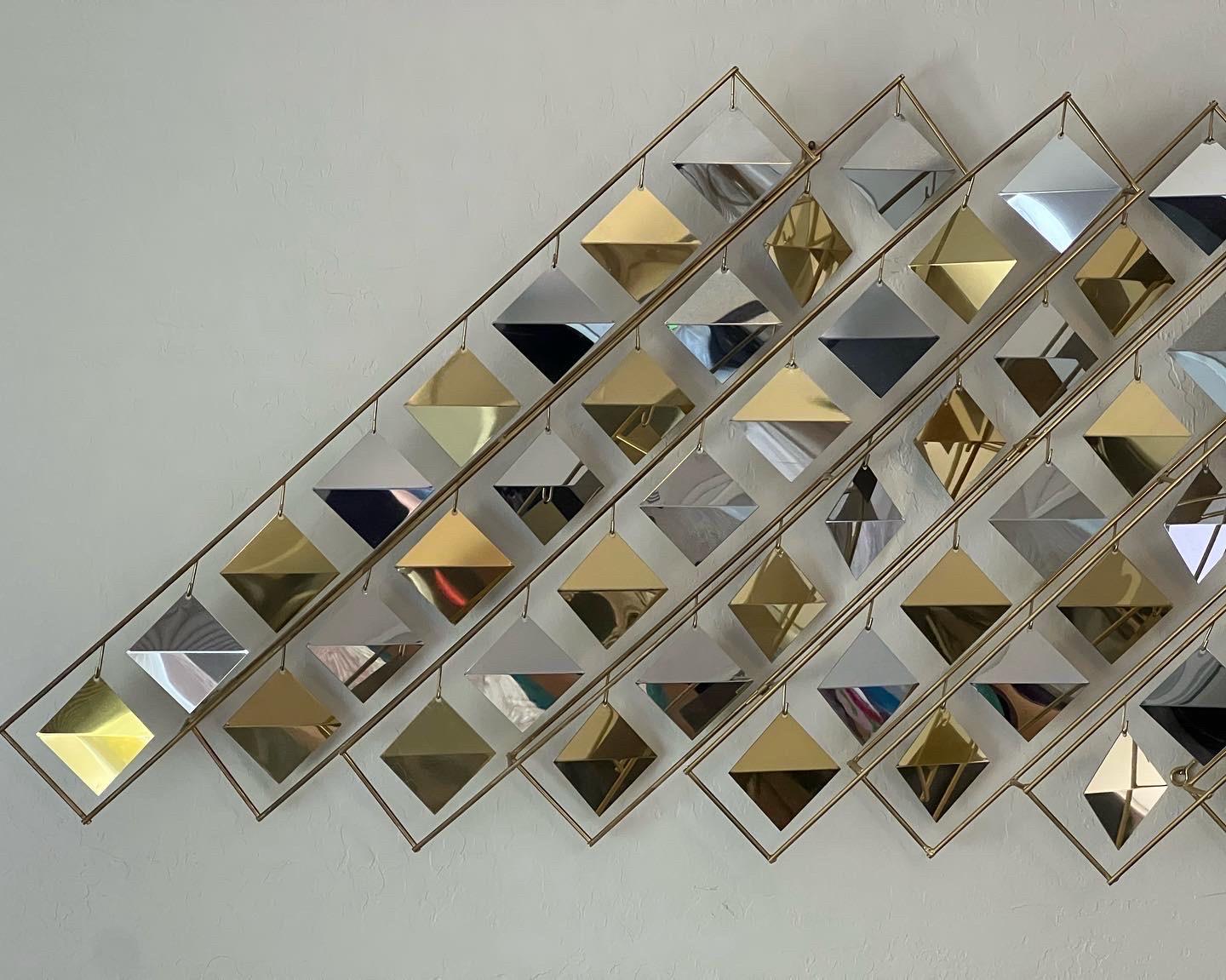 C. Jeré uncommon kinetic brass and chrome wall sculpture. It’s made of a brass frame with two separate parts that connect or can be displayed separately. It can also be positioned offset (not pictured). Polished brass and chrome bent diamonds hang