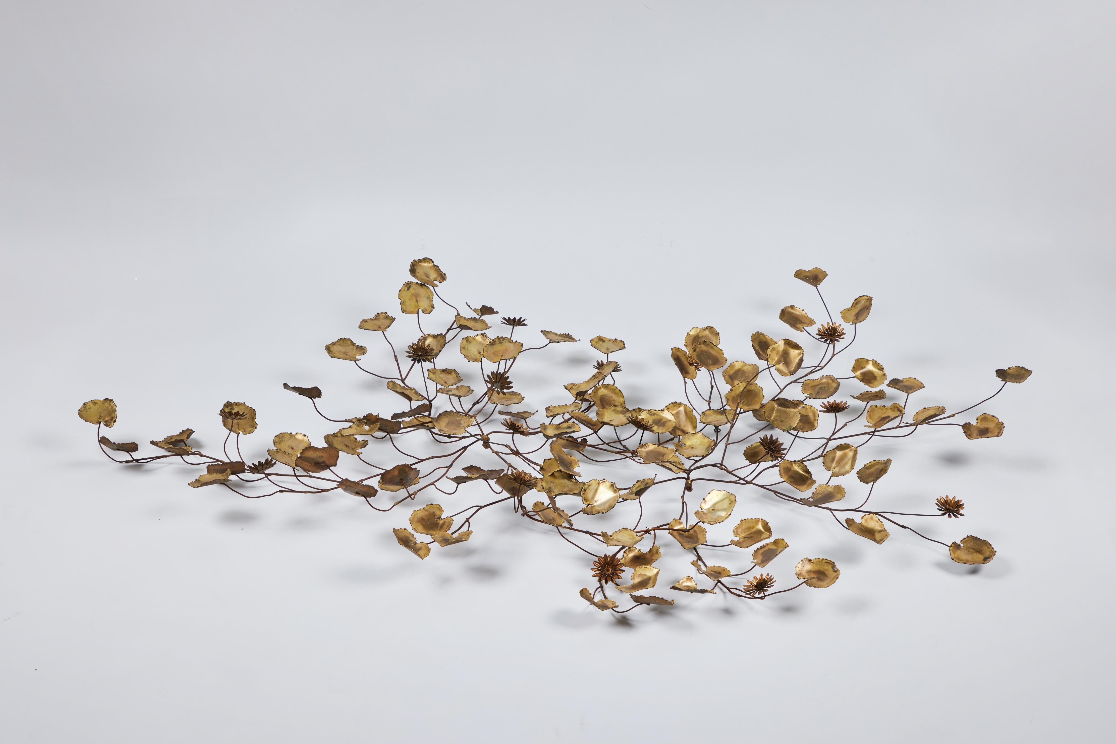 Light and Airy - this fantastic Mid Century wall sculpture is breathtaking. It is made up of a series of sculpted oxidized brass lily pads accented by a few brass lily flowers dispersed through a series of intertwined branches making this a