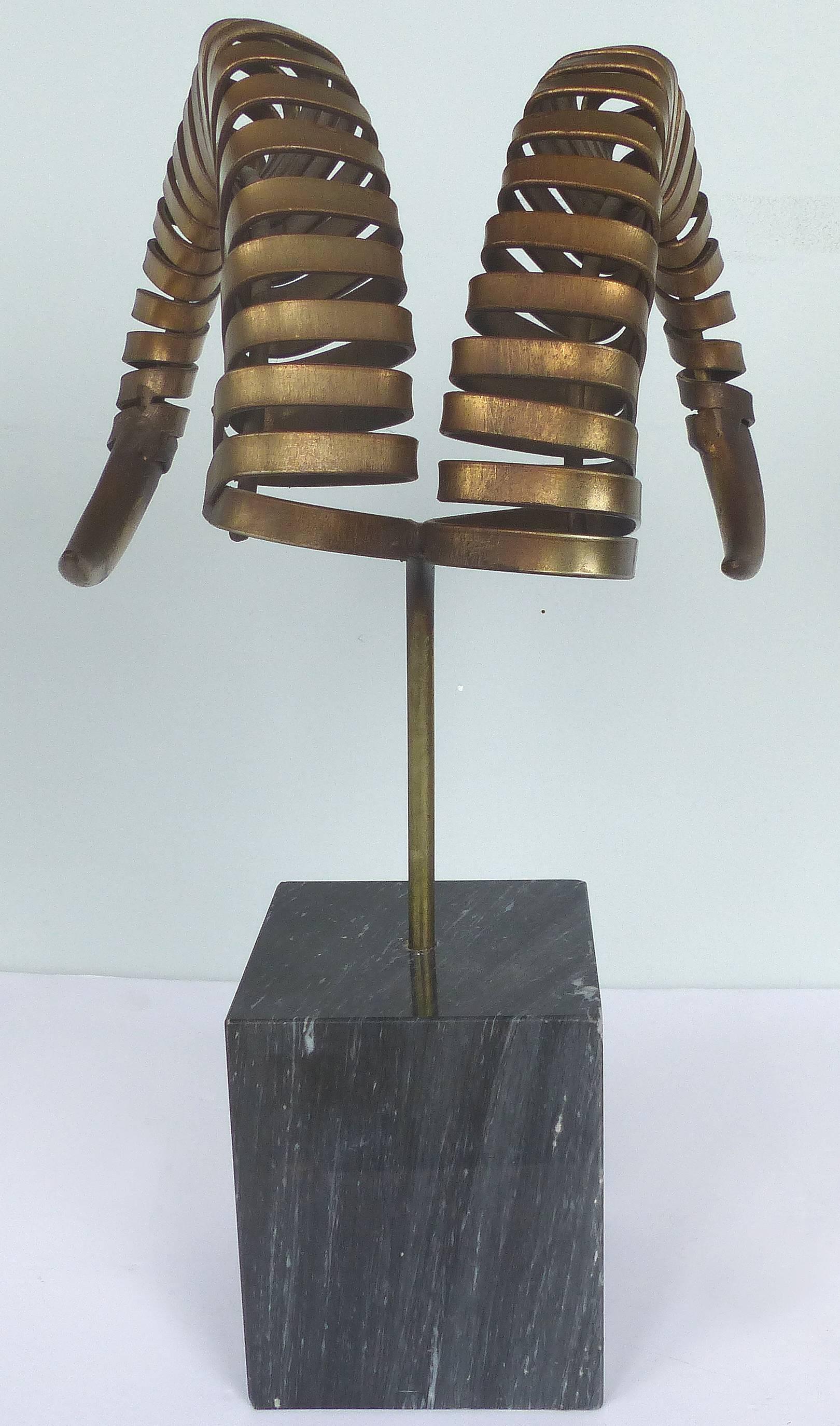 C. Jere Ram's Horn Sculpture on Marble Base, Twice Signed and Dated, 1983

Offered for sale is a rare and dramatic sculpture by C. Jere of ram's horns brass-plated metal sculpture on a marble square base. Signed on base of horns and dated 1983.