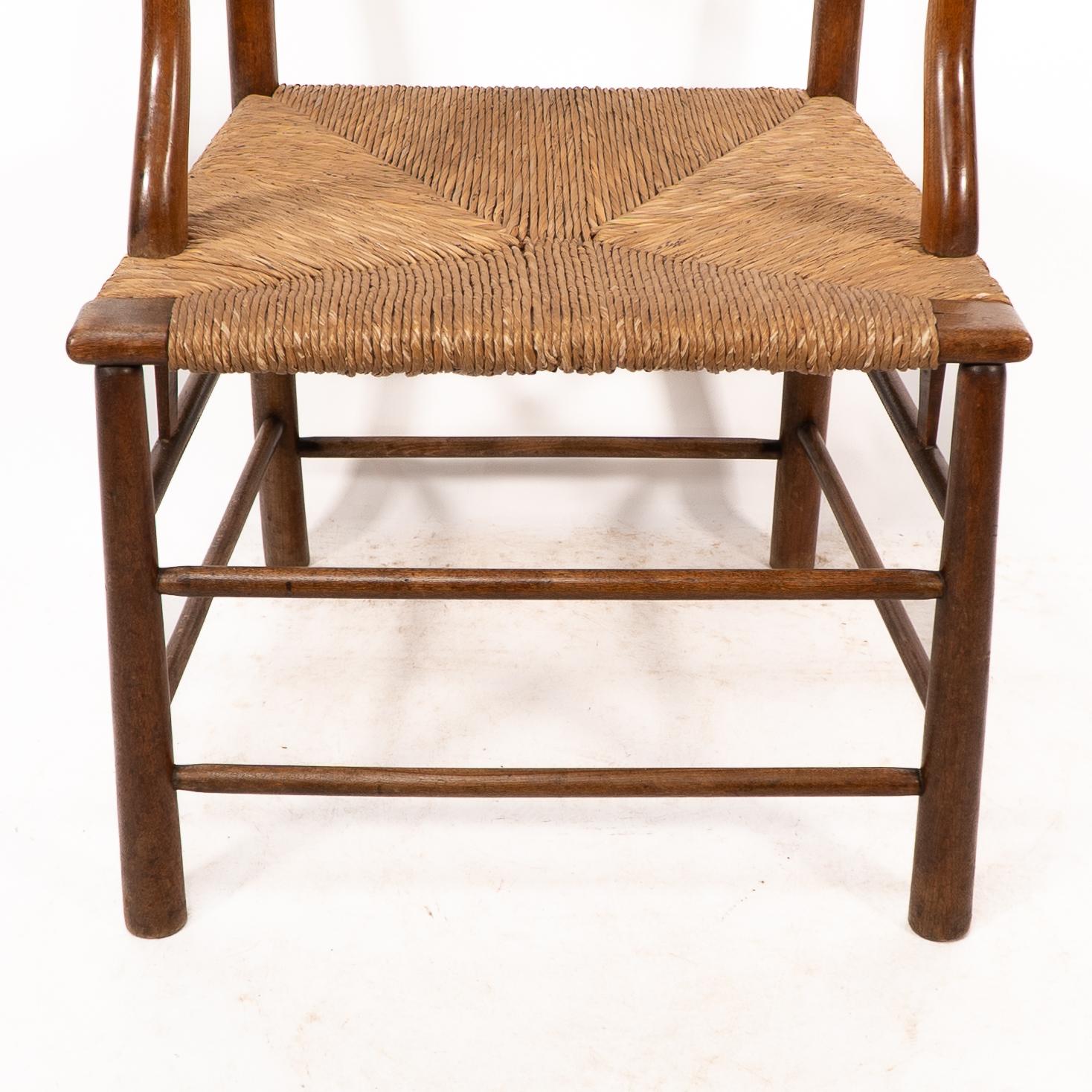 C. R. Ashbee. Un sillón Arts and Crafts con asiento de junco y respaldo de escalera Rush en venta