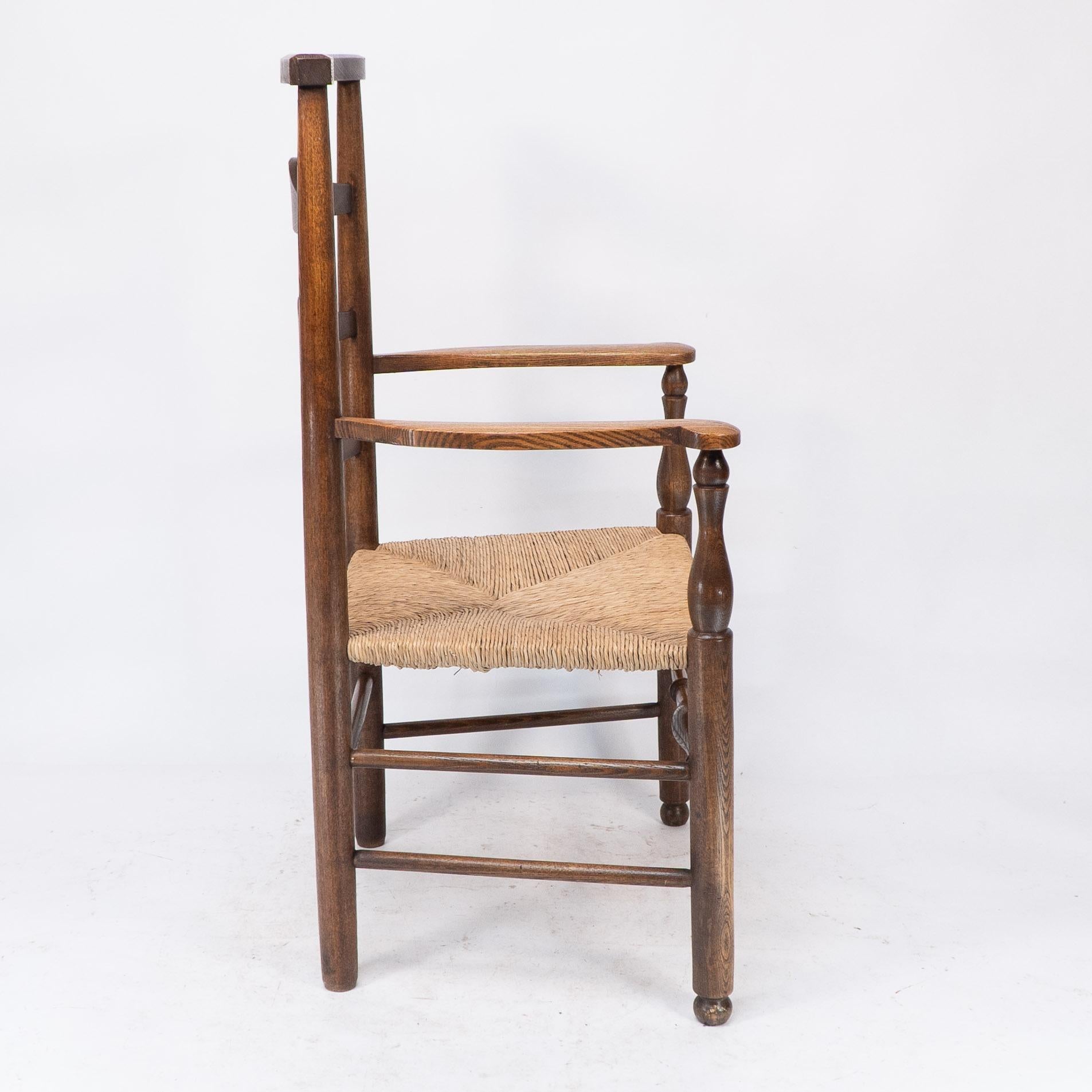 Arts and Crafts C R Ashbee attr. An Arts & Crafts oak ladder back armchair with re-rushed seat For Sale