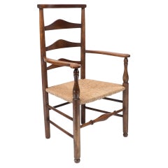 C. R. Ashbee attr. Un sillón Arts & Crafts con respaldo de escalera de roble y asiento reempotrado