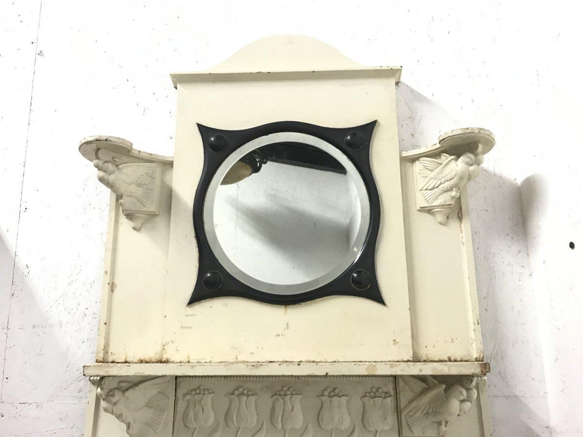 C. R. Ashbee, zugeschrieben. Ein gusseiserner Kamin im Arts & Crafts-Stil, ein zentraler kreisförmiger Spiegel mit stilisiertem Kupferrahmen, der von zwei sich küssenden Tauben überblickt wird, mit Ausstellungsflächen über ihren Köpfen,
