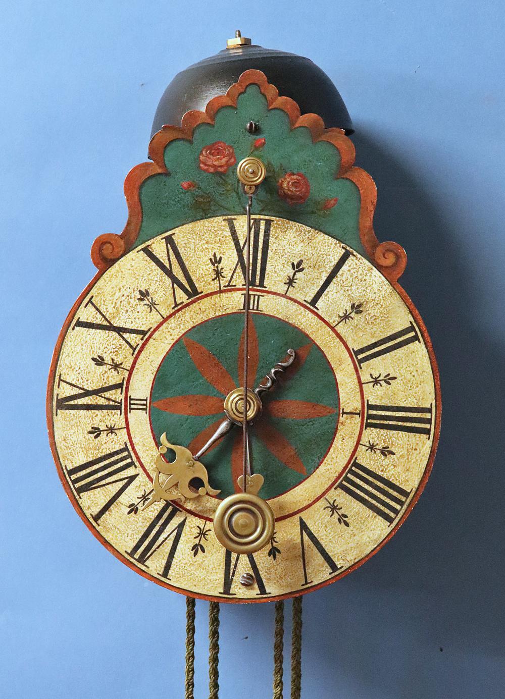 Description: 
A very early 18th century ‘hook and spike’ German 30-hour wall clock.

Dial: 
The painted iron dial has a shaped crest above decorated with a bouquet of roses, Roman numerals for the hours and an inner chapter with the quarter-hour