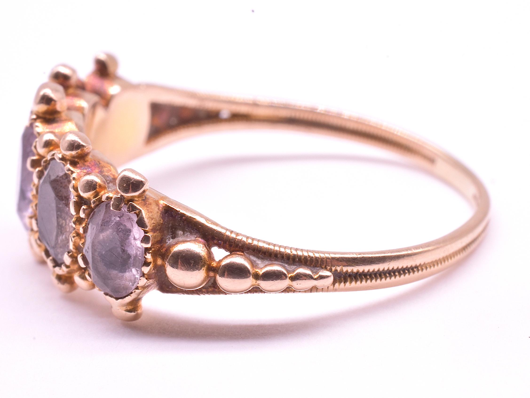 This is an unusual 5 stone early half hoop ring and an early Georgian closed gold back which is an art form unto itself. The stones are ornamented with gold balls laboriously hand forged in graduated sizes by a talented 18th century goldsmith, along