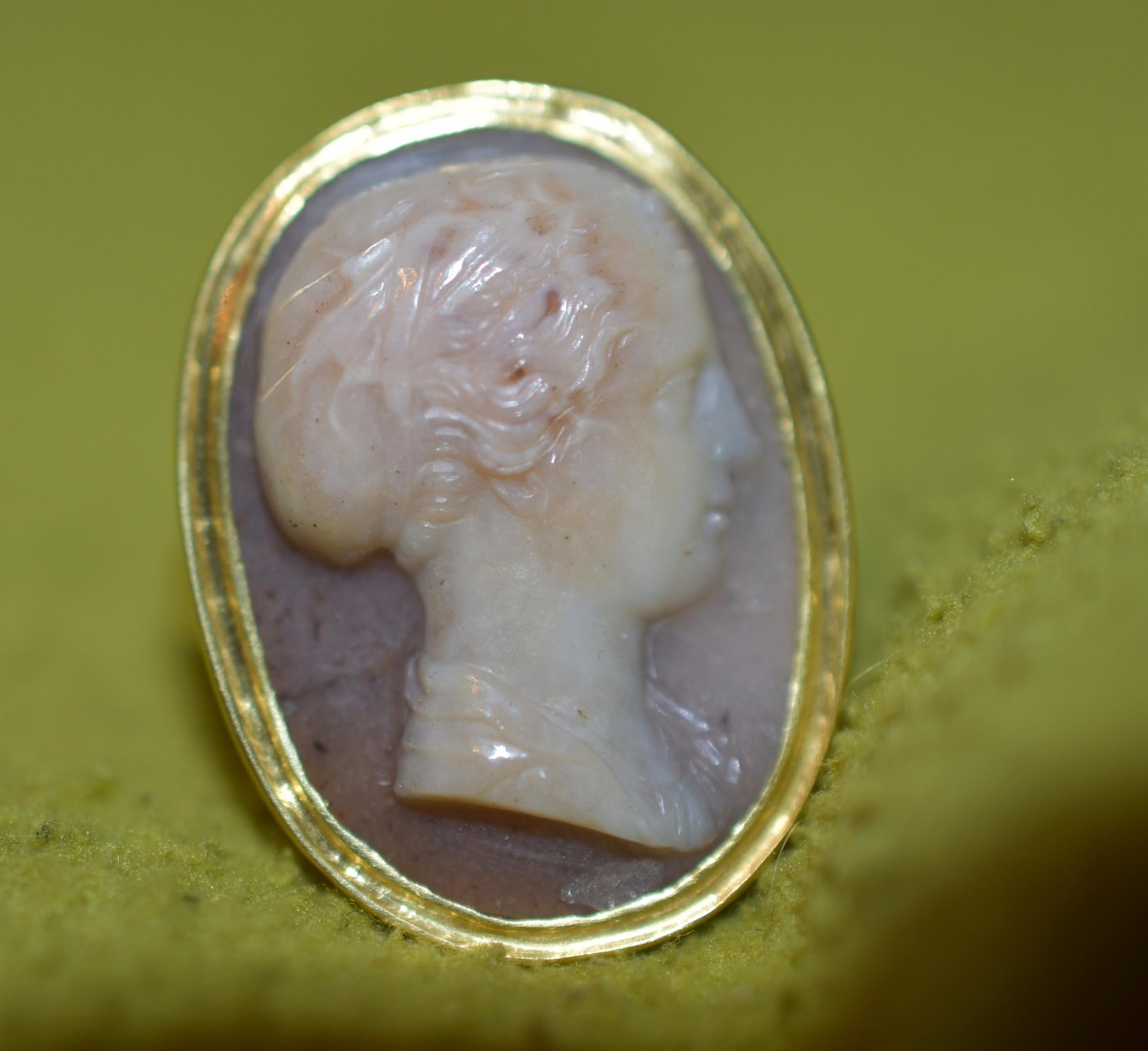 Utilizing the natural features of the blush and gray speckled agate with a lovely mottled appearance and demonstrating the fine carving that this circle of Italian carvers were known for, our ring is a sensitive portrayal of Sappho, an early poetess