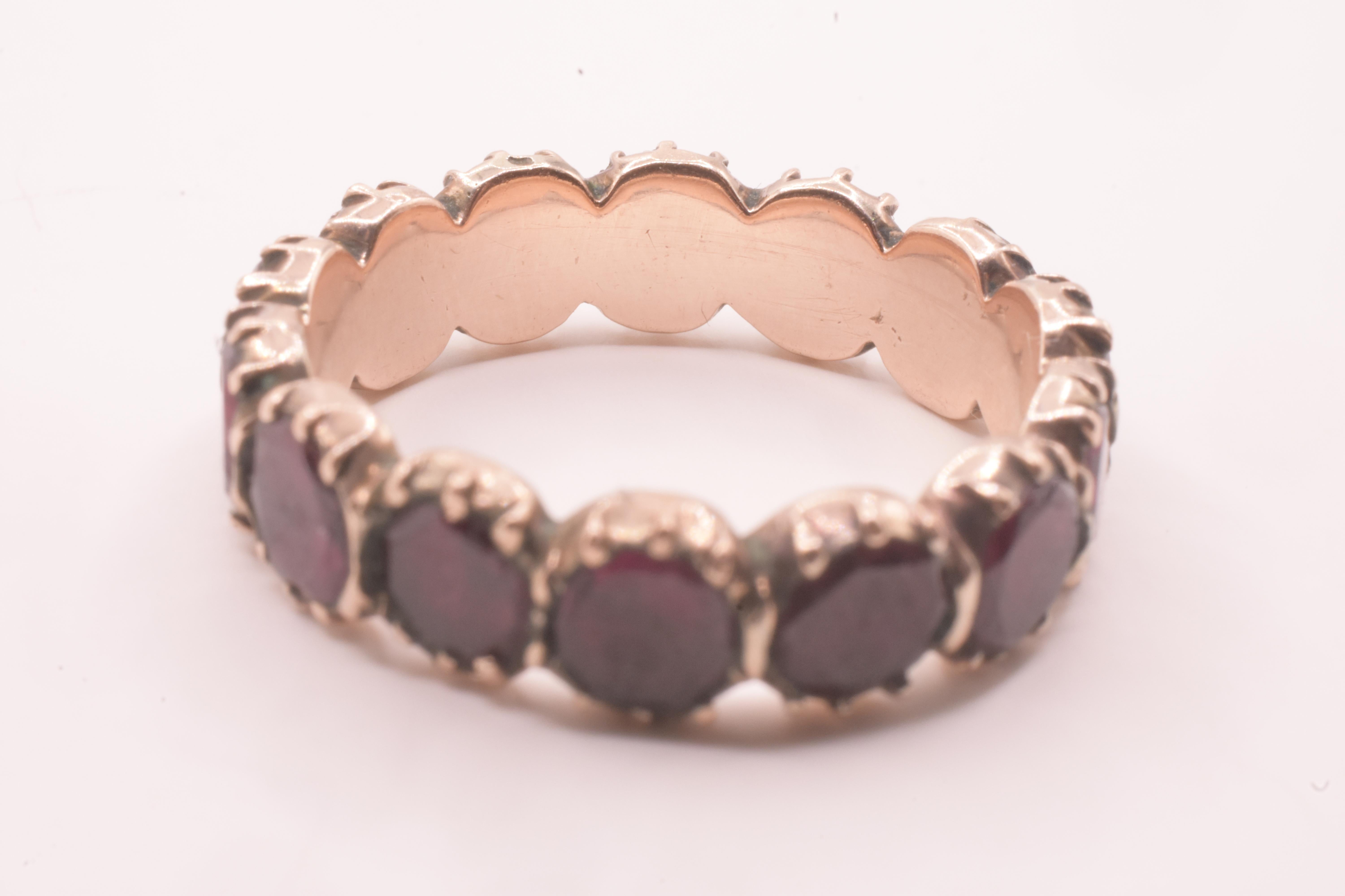 Fascia eternità in oro 15 carati con granato almandino georgiano. Le fedi eterne venivano realizzate come anelli di fidanzamento o per anniversari speciali e i granati almandini erano molto utilizzati in quest'epoca perché si riteneva che i granati