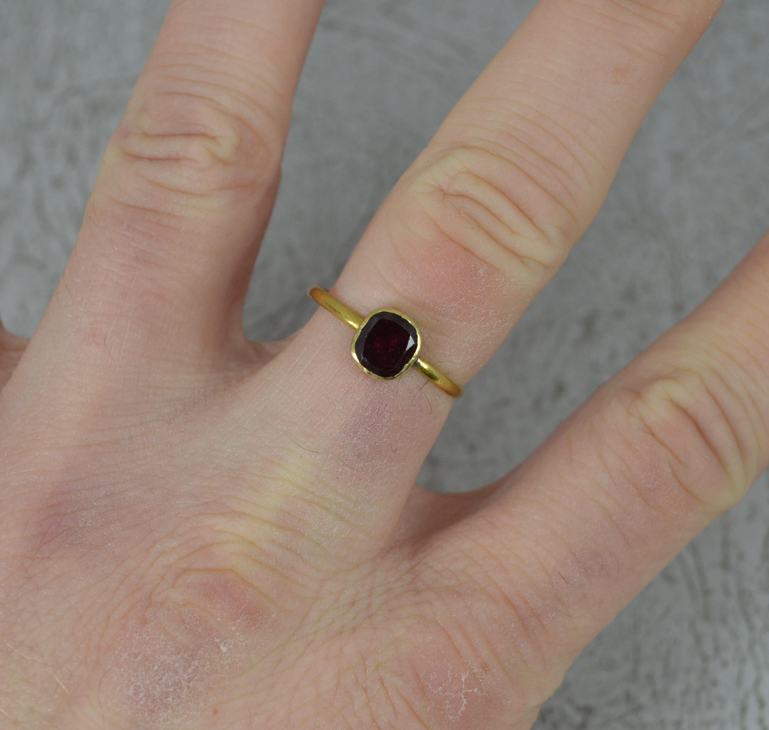 A superb Georgian period ring. c1790.
Solid 22 carat yellow gold thin band with single garnet.
5.8mm x 6.7mm garnet in full fine bezel setting. In foiled, closed back. 
Georgian era stone applied onto a Georgian era shank.
1.5mm wide band