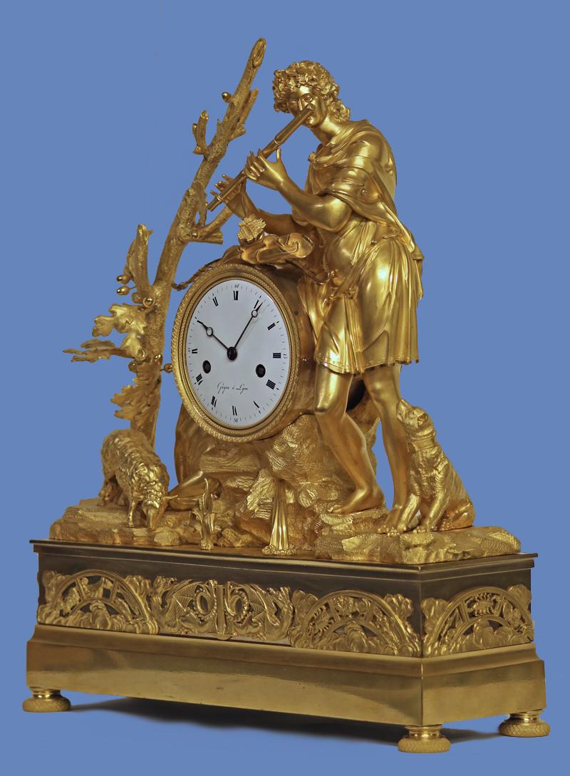 Case: 
The well-cast and finished ormolu case depicts a large male figure, Orpheus, standing on rockwork while leaning on the clock and playing the flute. He is surrounded by several animals including a cow, sheep and dog and the whole stands on a