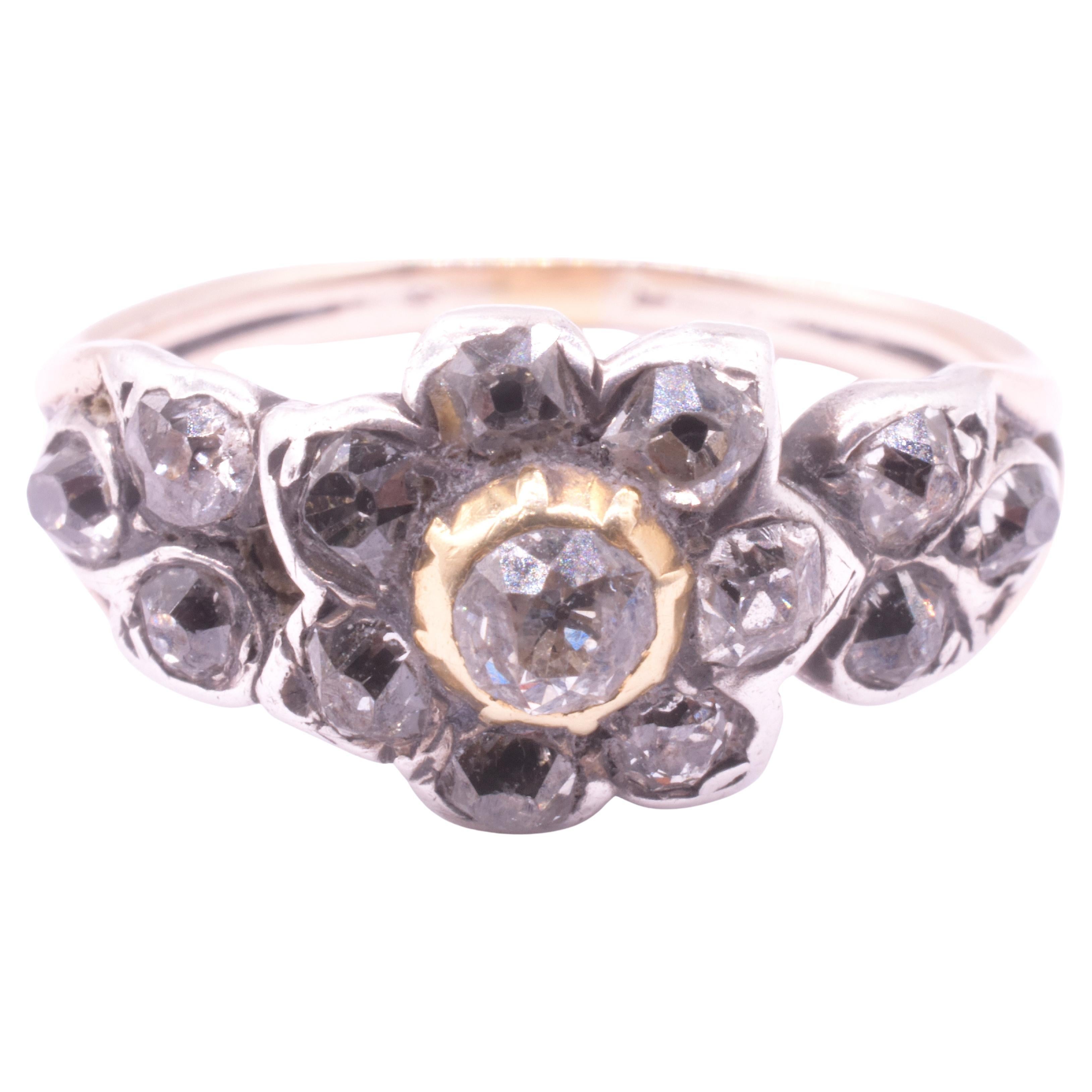  Adoriamo questo fantasioso anello georgiano con diamanti a grappolo e il modo in cui il fiore a grappolo ha la forma di un petalo, un lavoro a mano che richiede molto tempo. L'anello è montato su una fascia in oro 18 carati, come si addice a un