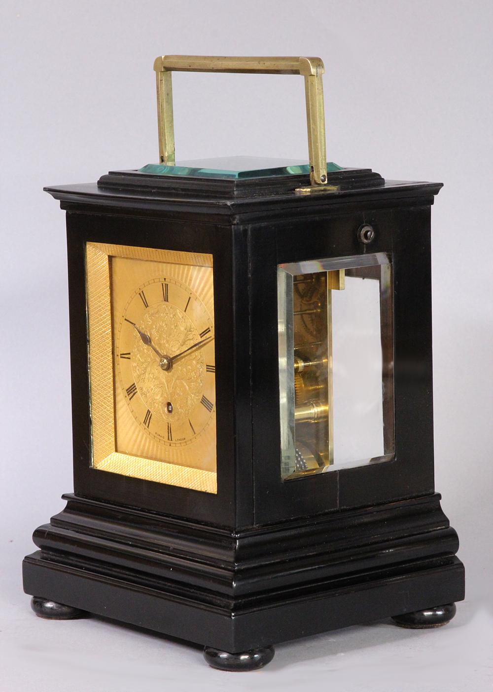 Maker: 
Alexander Purvis, London.

Case: 
The small ebonized case has a shaped. molded base, a brass hinged handle, bun feet and thick beveled glasses to the sides and top.

Dial: 
The gilt dial has engine-turning around the outside of the