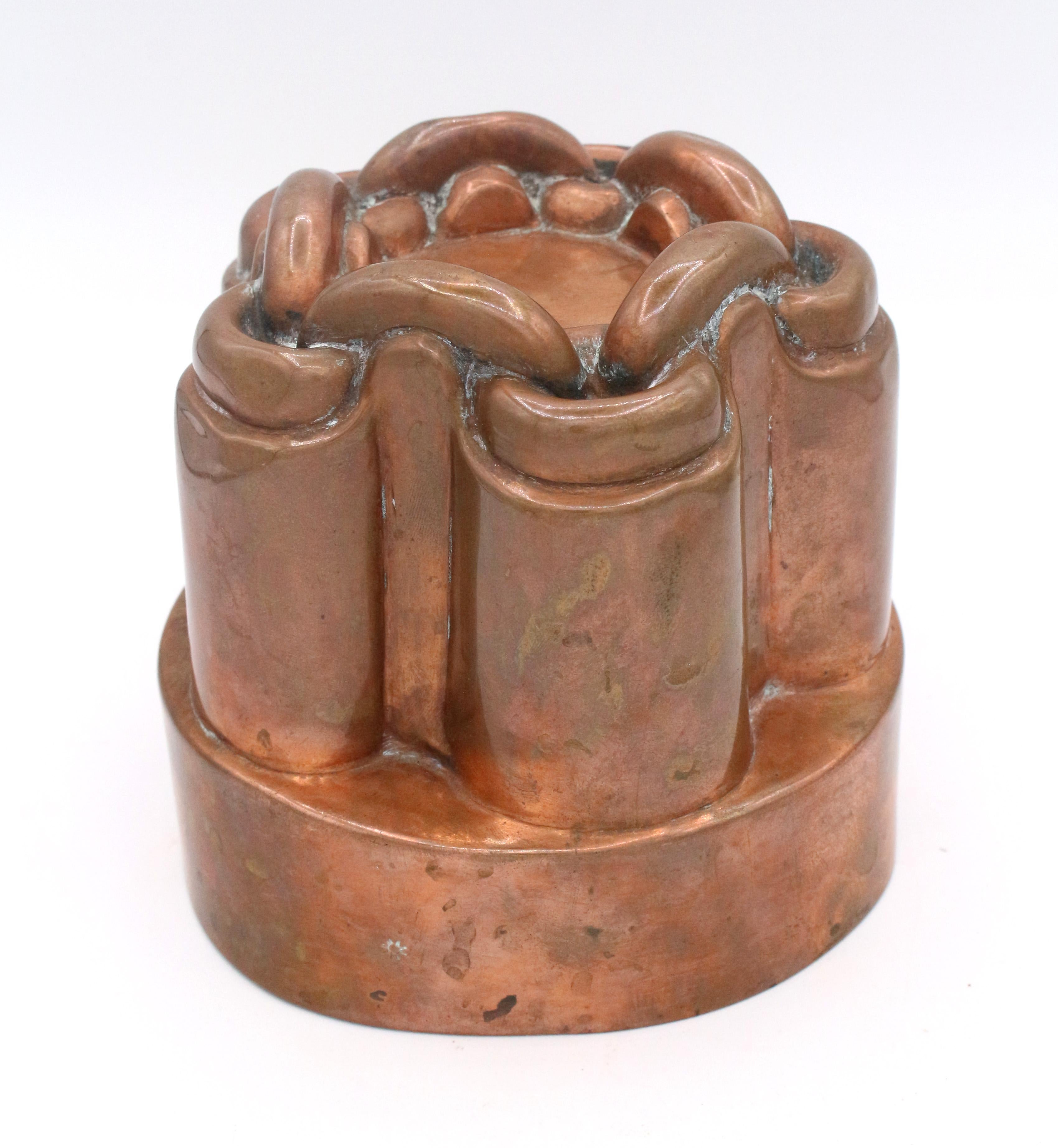 A c.1860-75 English copper jelly mold by Benham with orb & cross opposing sun marks. Chain motif.
5