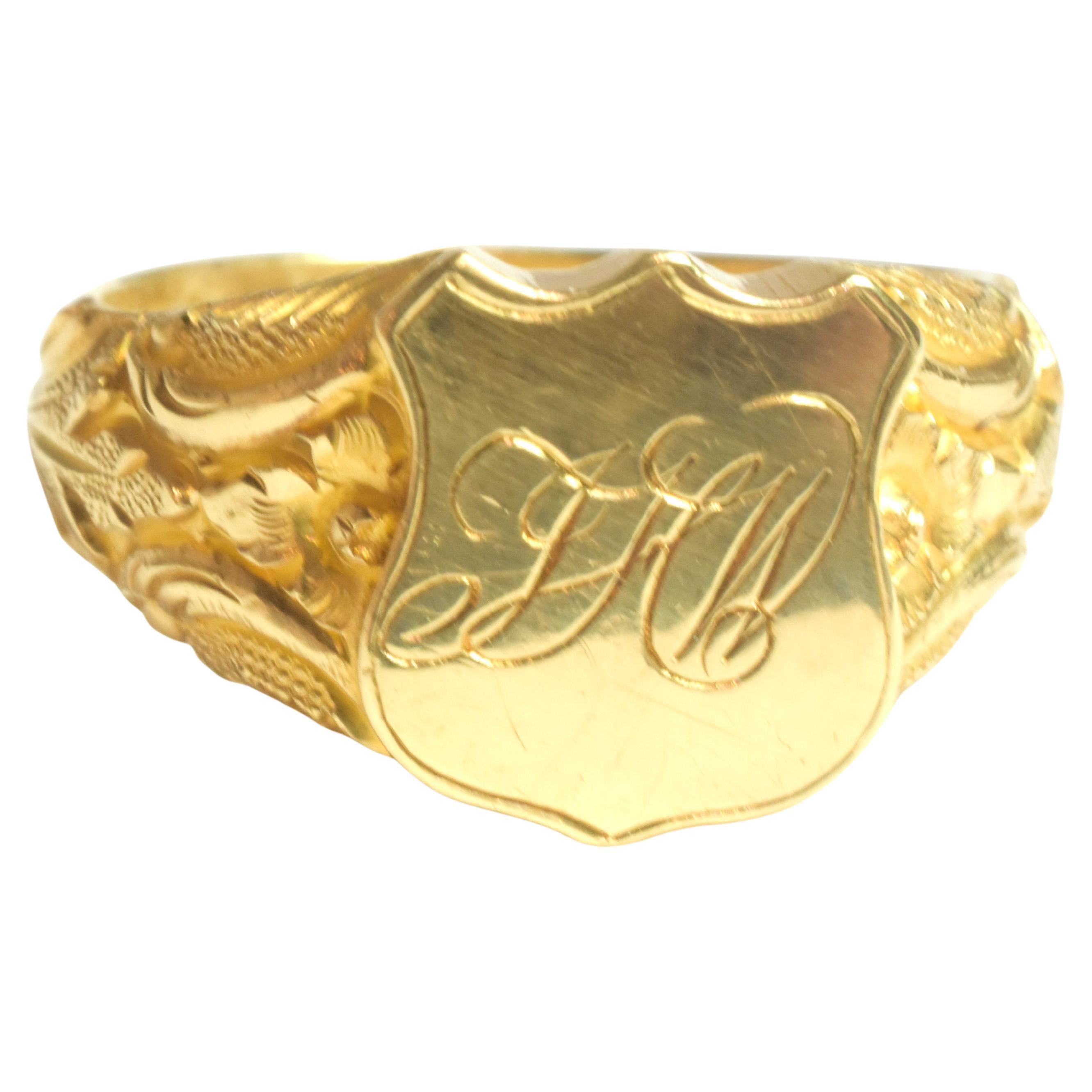  20 carat engraved monogram signet ring skillfully hand carved with deeply carved repousse shoulders set in an gold shield shaped bevel with monogrammed  initials JHW. Chased ornate repousse flowers and leaves along the shoulders are masterfully