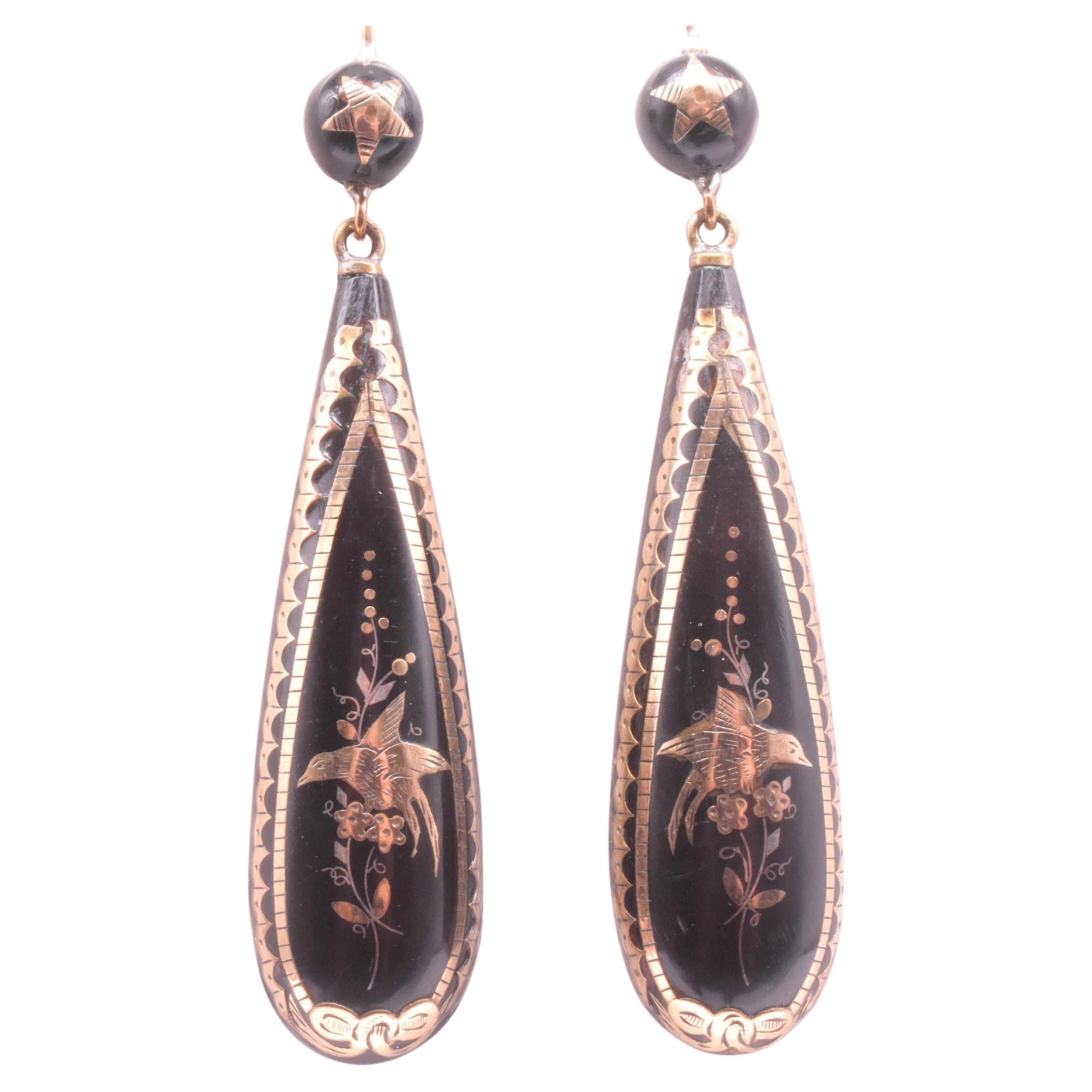 Wonderful pique earrings in the traditional pendeloque shape, with the bottom portion carved in the round at the bottom and carved to a point at the top and a pique ball top with inlaid star. The birds each point in the opposite direction indicating