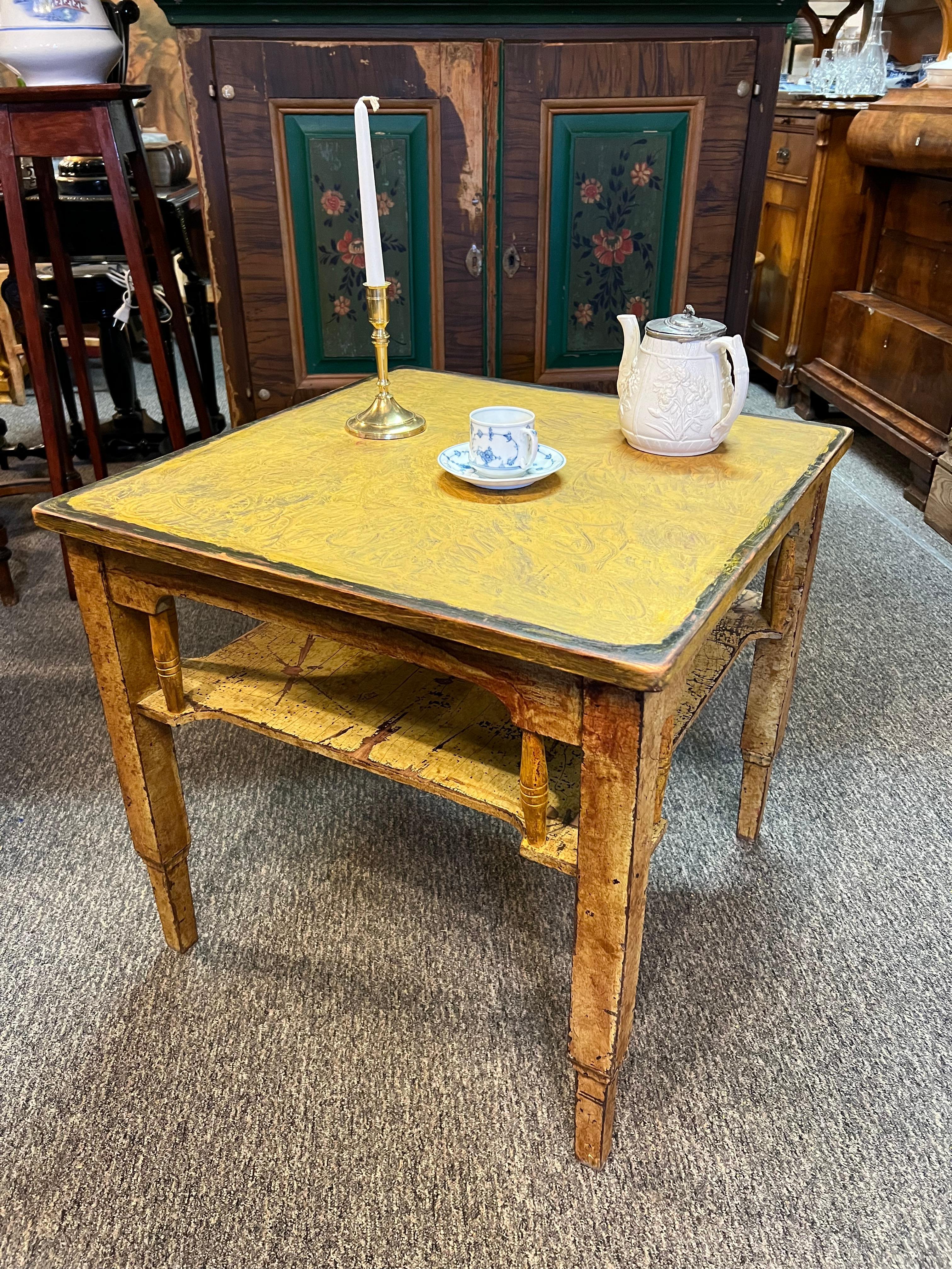 A striking primitive antique square coffee table from late 19th-century Scandinavia (Norway / Sweden). Handcrafted from solid pine, it features an original hand-painted finish and a beautiful, timeworn patina. Influenced by the Arts & Crafts